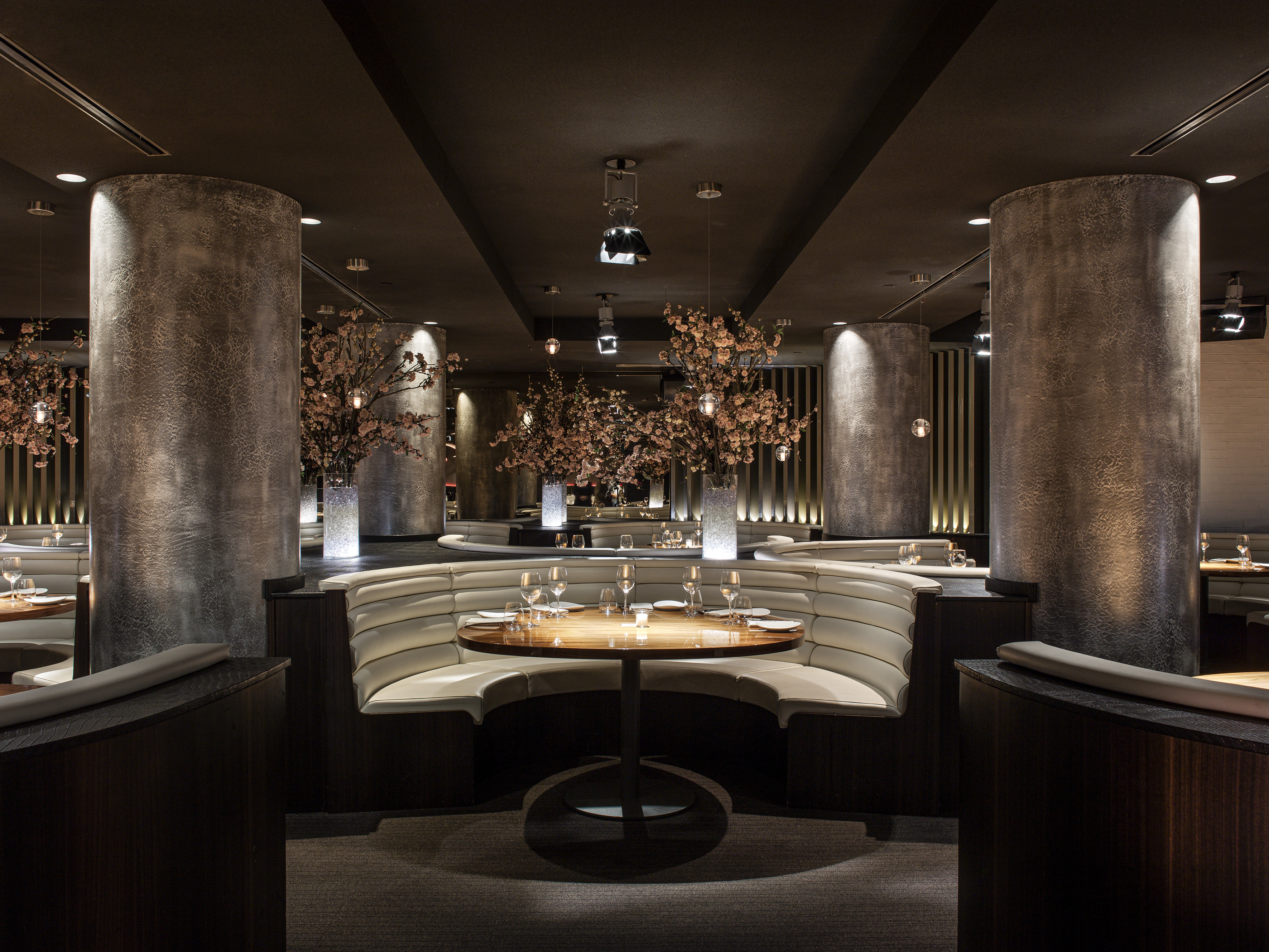 Elegant restaurant with cream dining booths, wood tables, and cherry blossom decor.