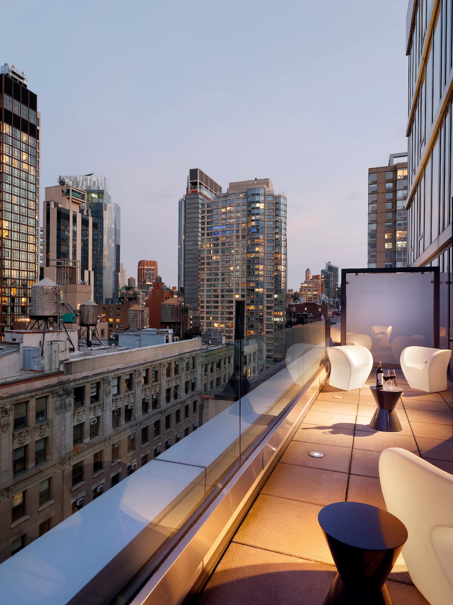 a balcony with chairs and tables in a city