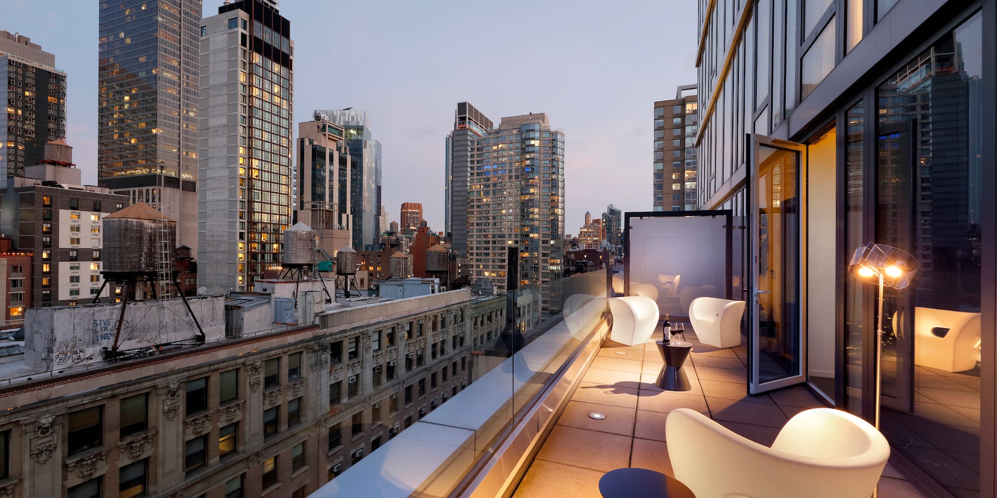 a balcony with chairs and tables in a city
