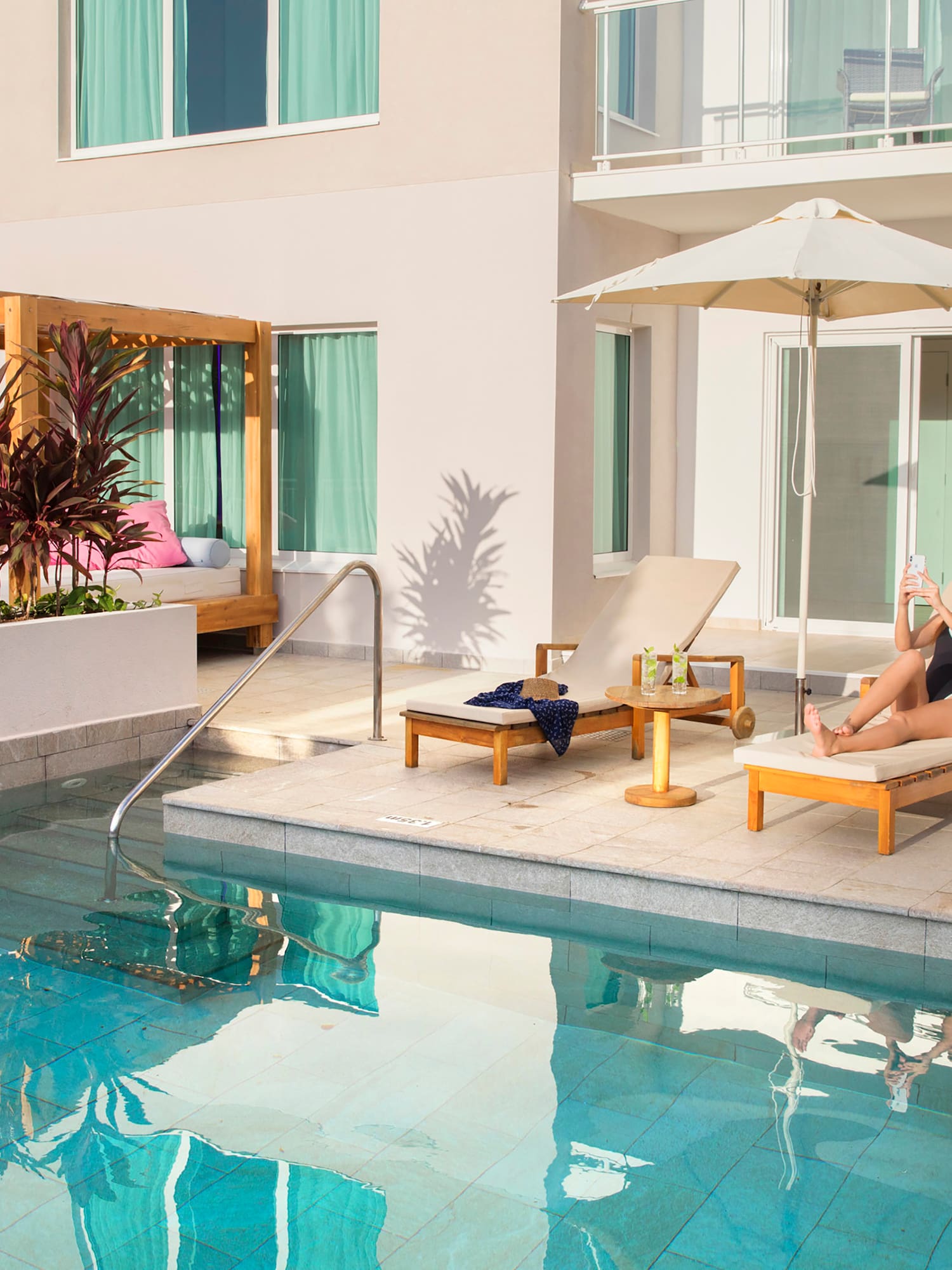 a man and woman sitting in chairs near a pool