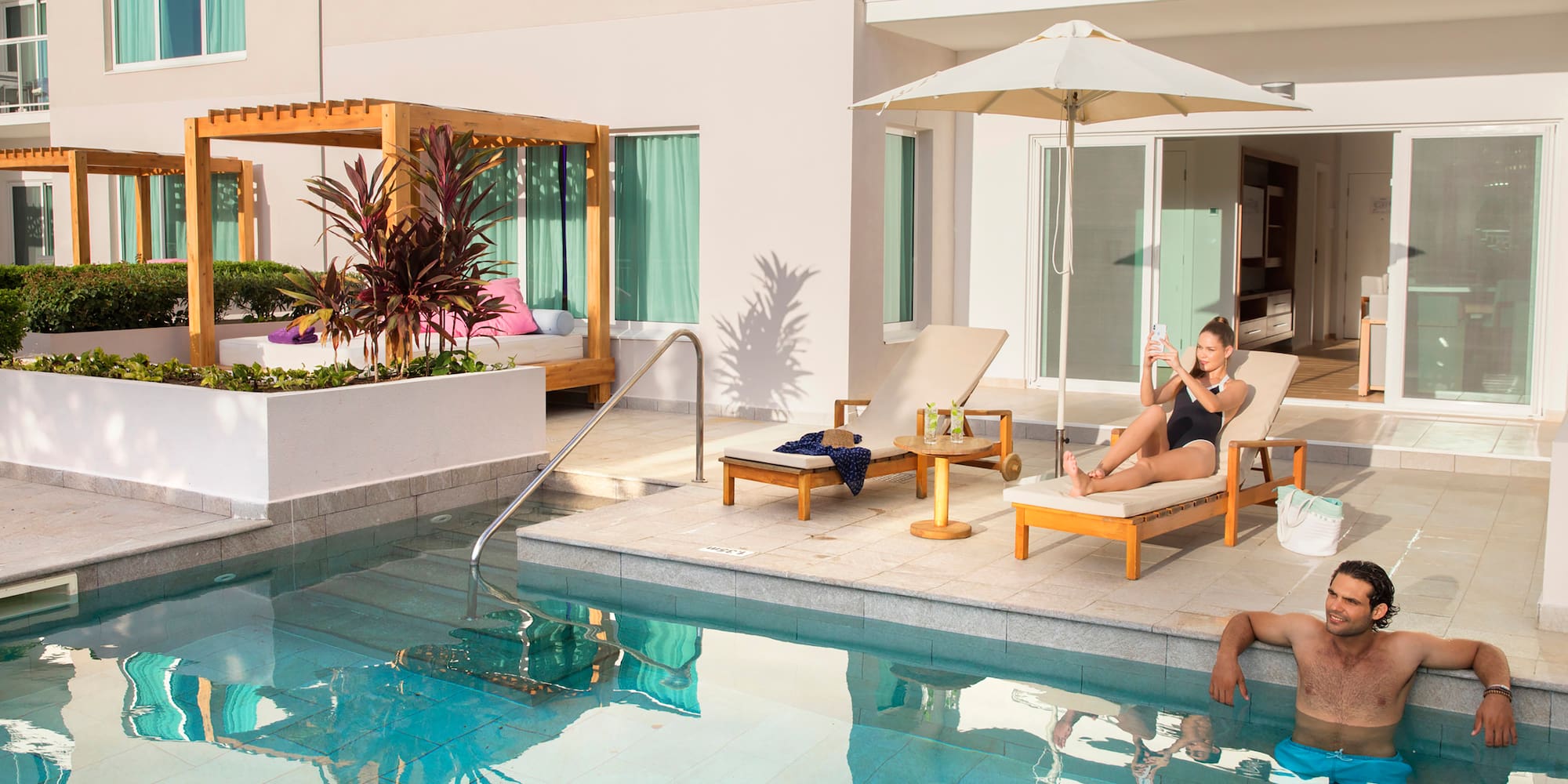 a man and woman sitting in chairs near a pool