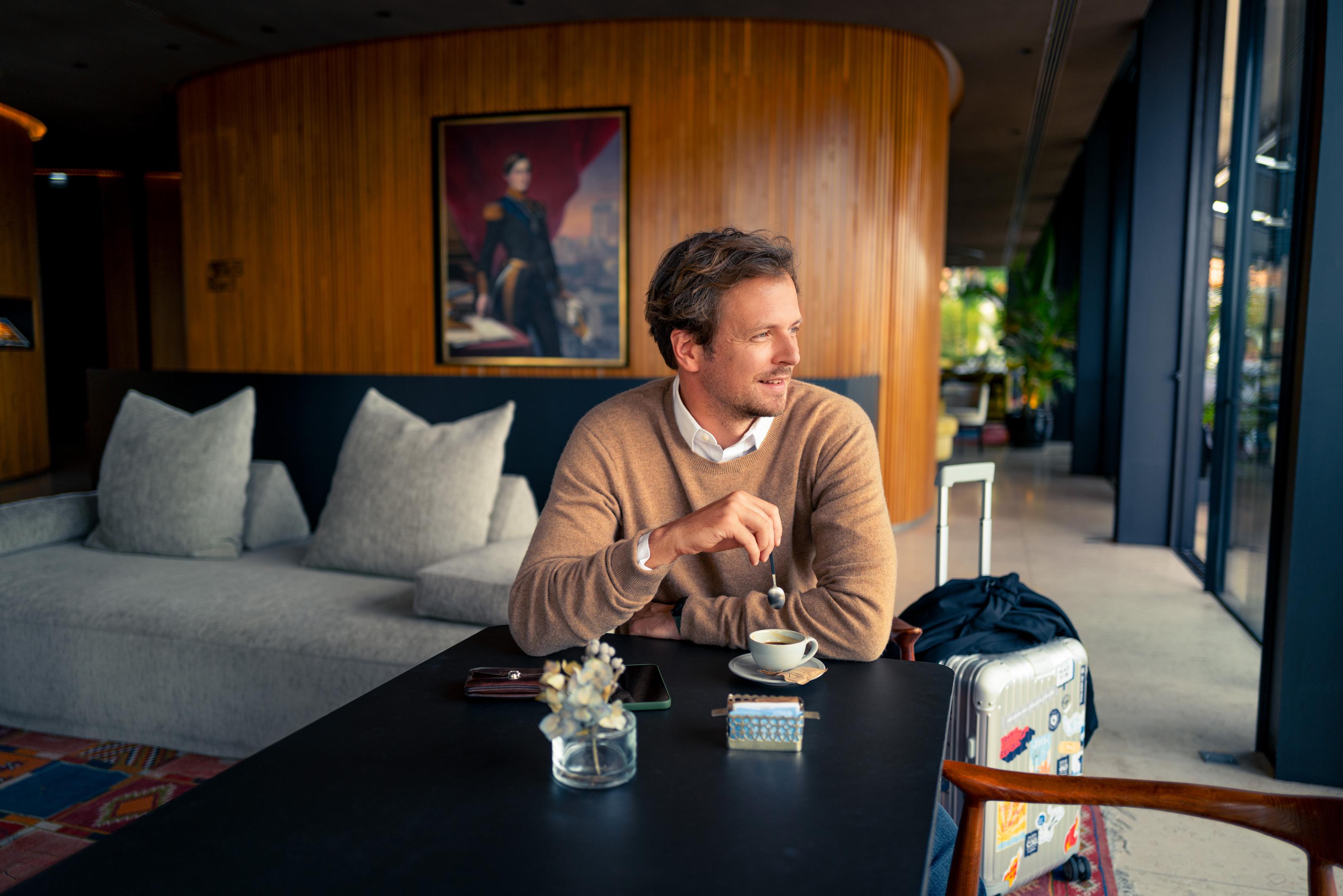 a man sitting at a table with a cup of tea