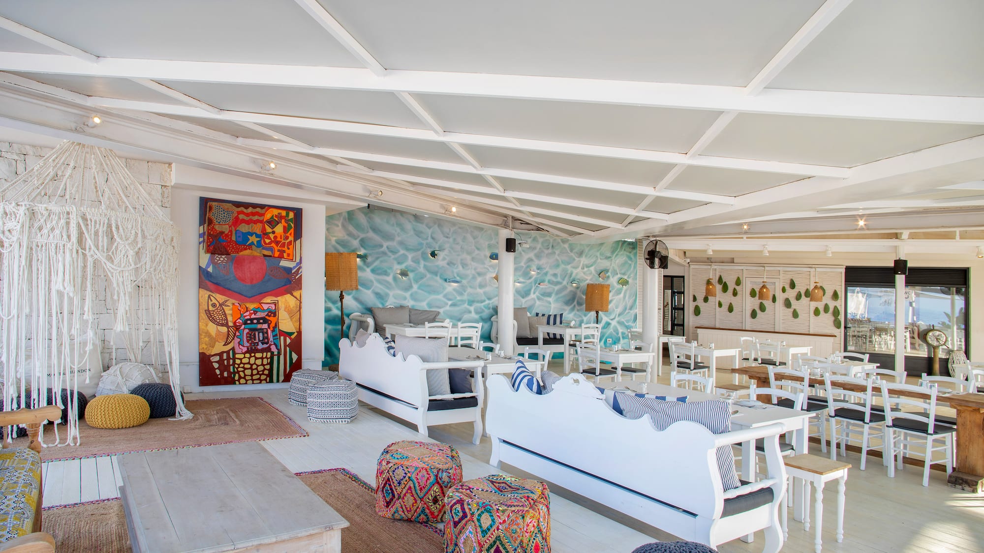 a room with white furniture and colorful pillows