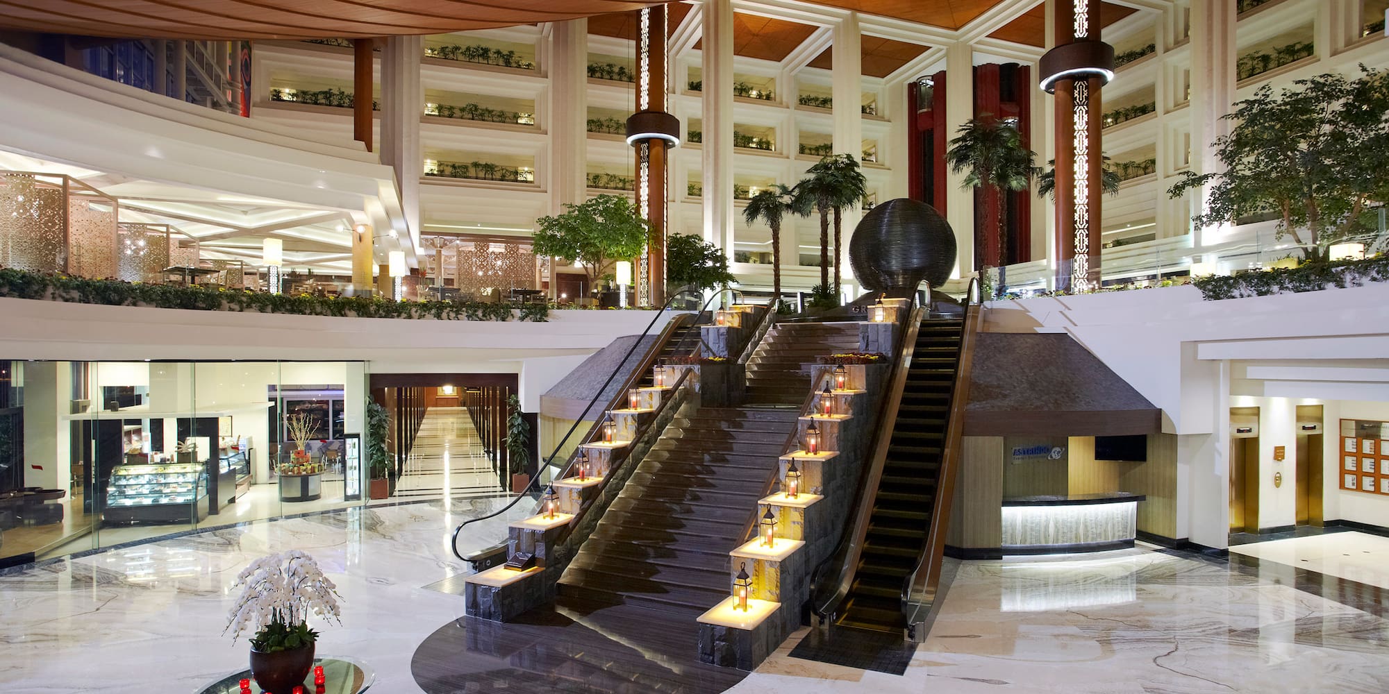 a large building with stairs and palm trees