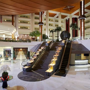 a large building with stairs and palm trees