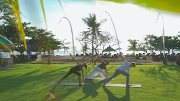 a group of people doing yoga on mats on a grass field