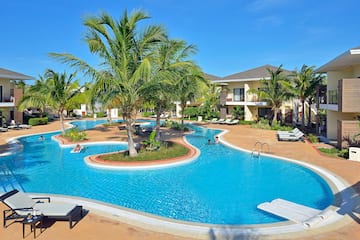 a pool with palm trees and people in it