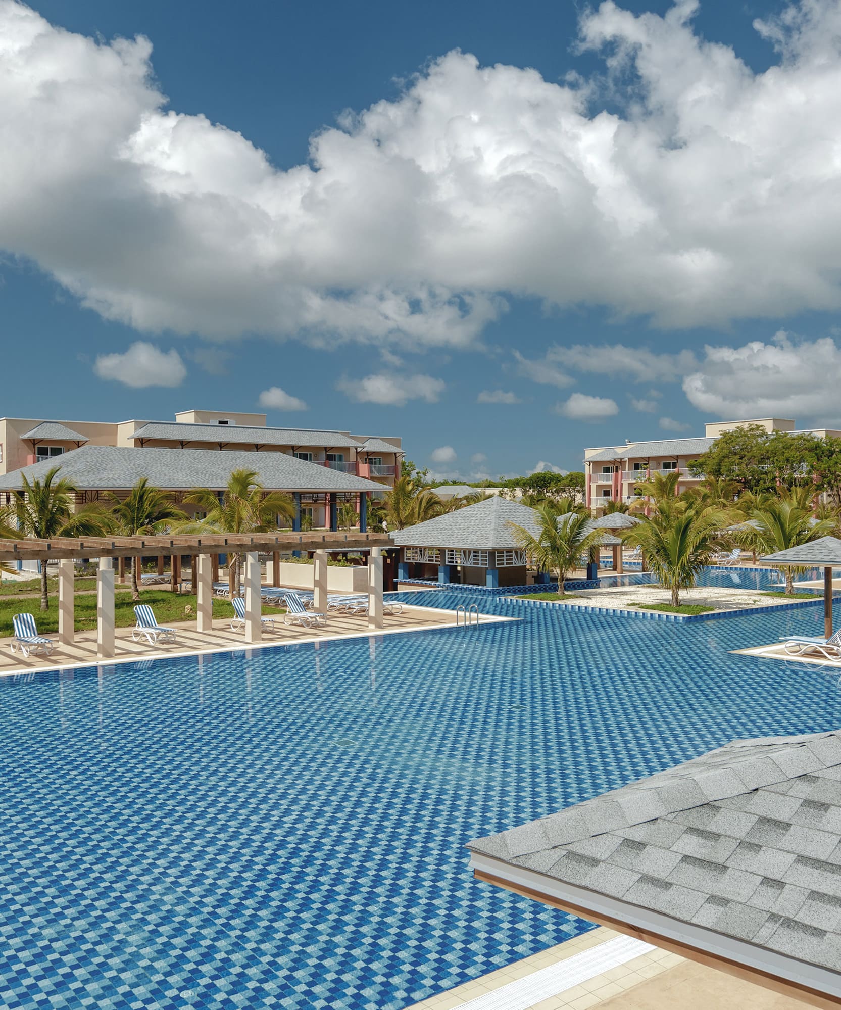 a pool with umbrellas and chairs in the middle of it