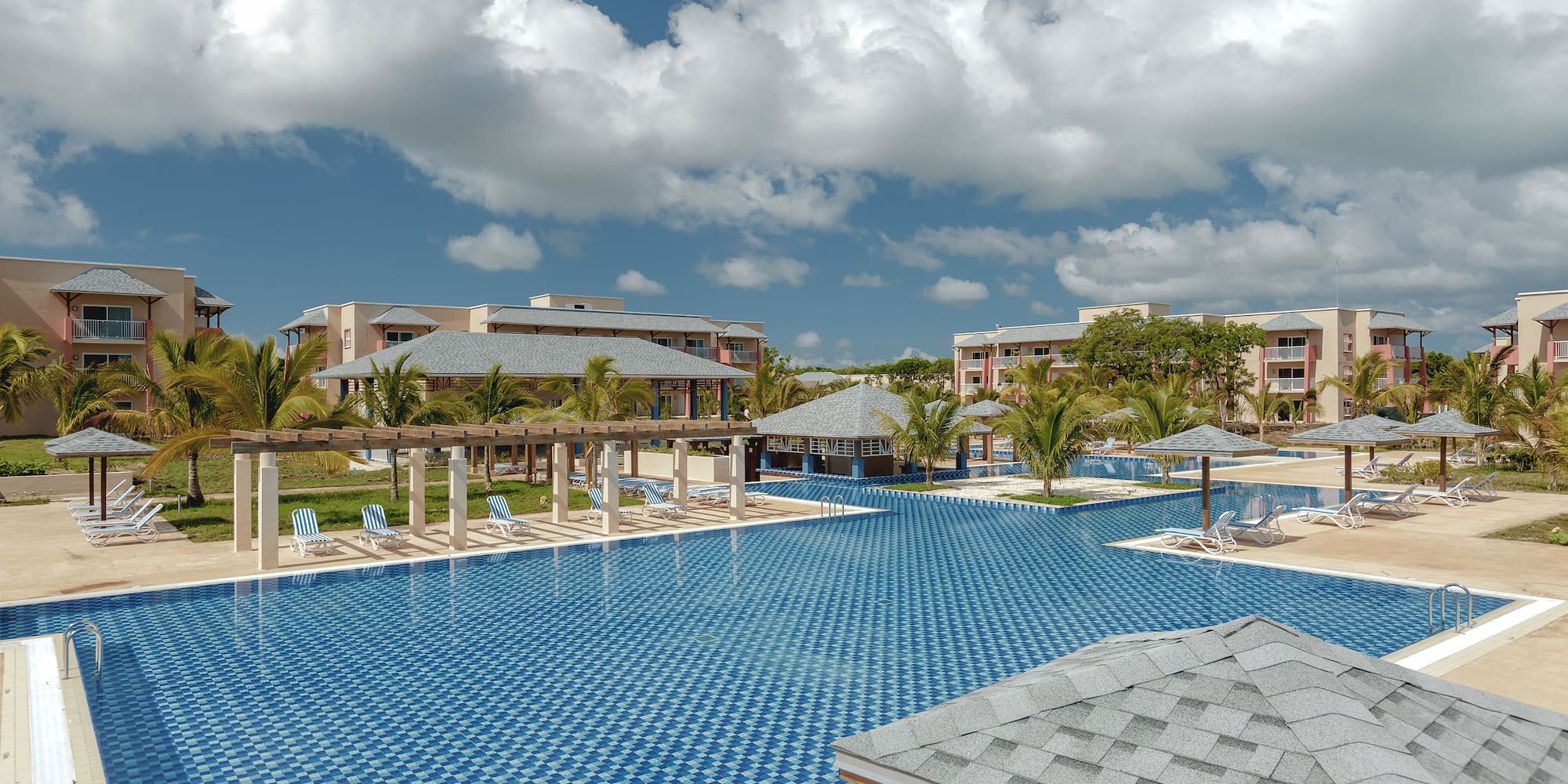 a pool with umbrellas and chairs in the middle of it