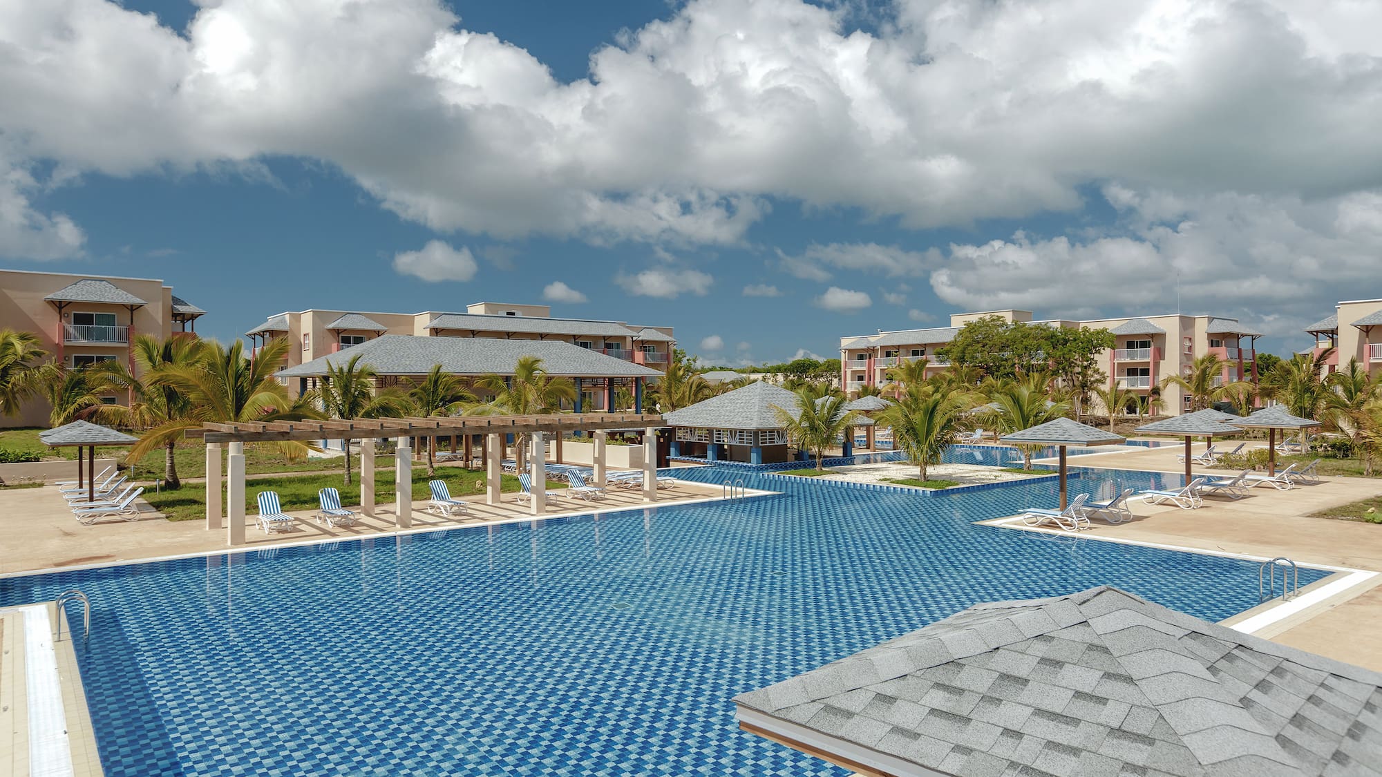 a pool with umbrellas and chairs in the middle of it