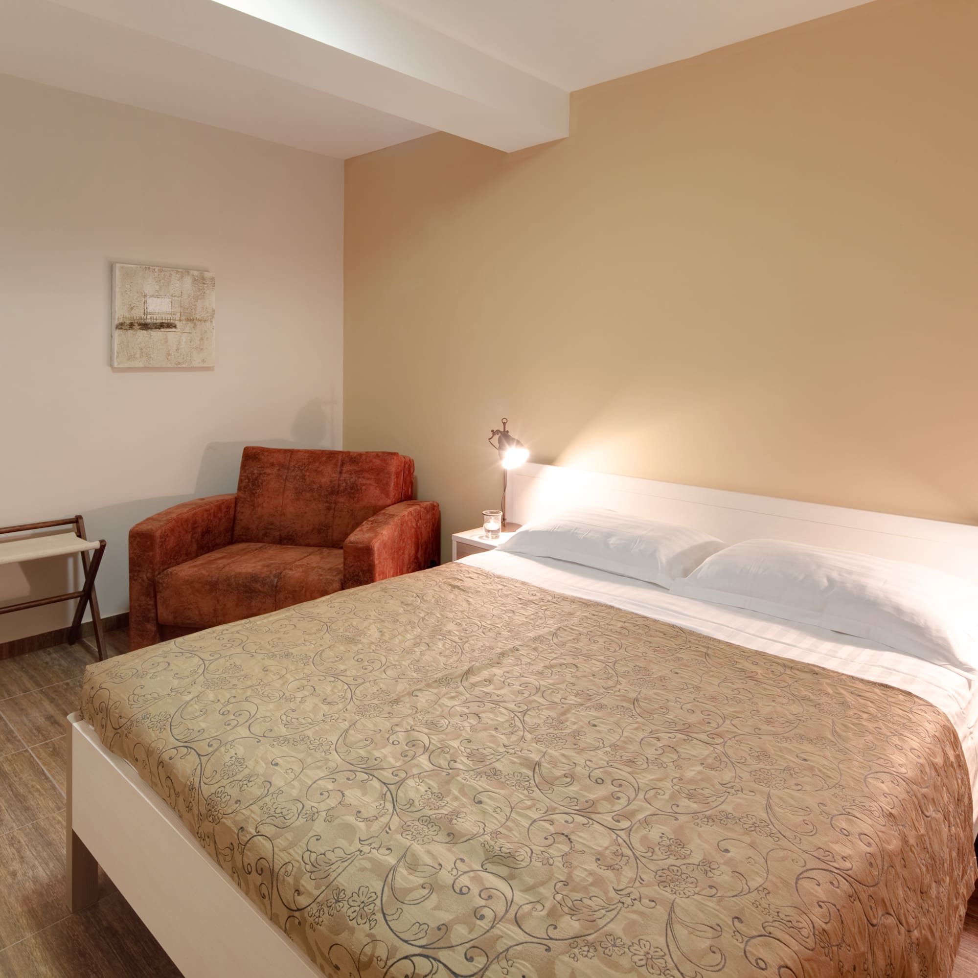 a bed with a lamp and a chair in a room