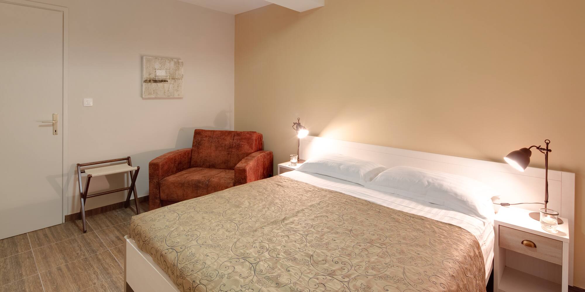 a bed with a lamp and a chair in a room