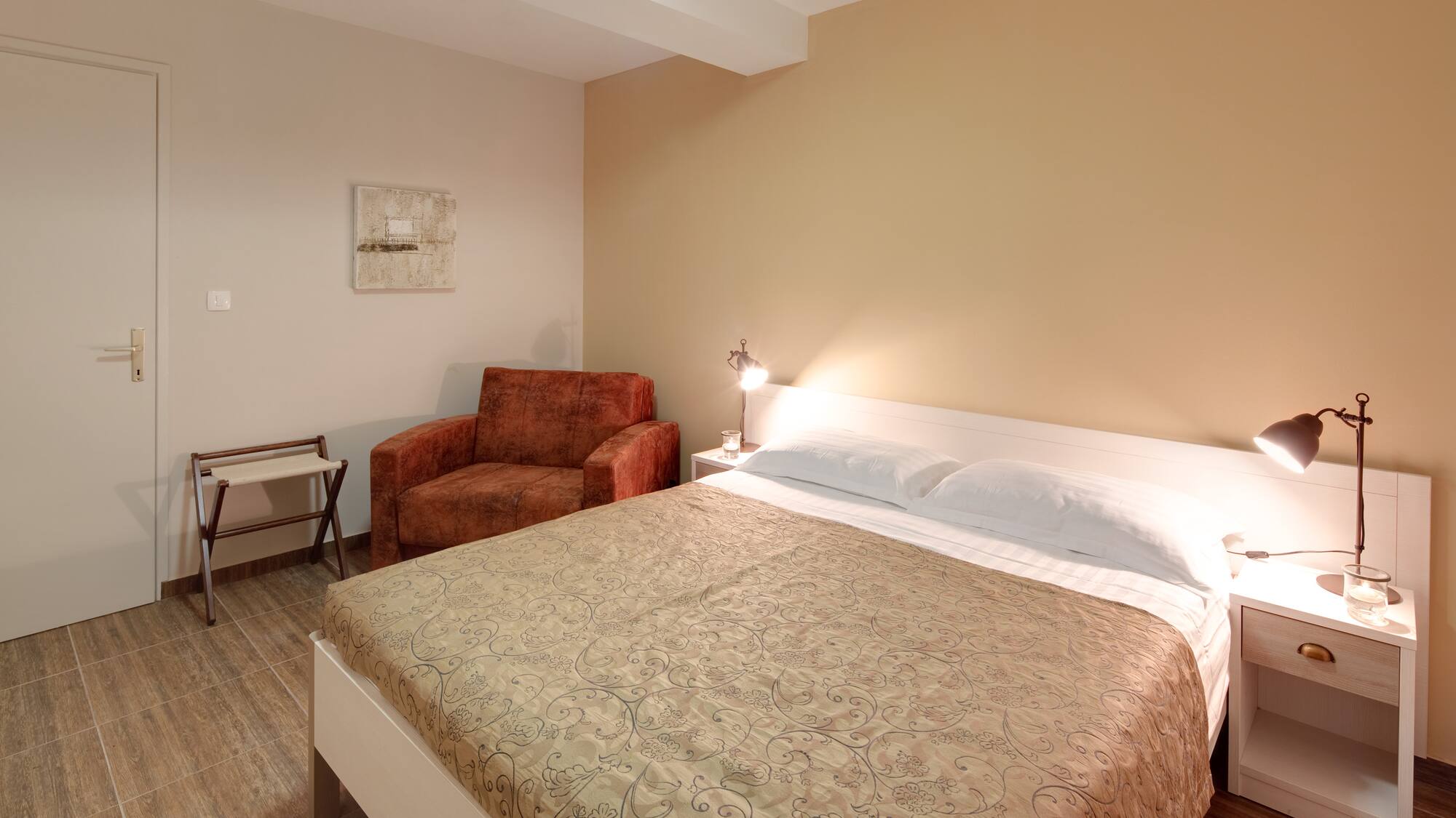 a bed with a lamp and a chair in a room