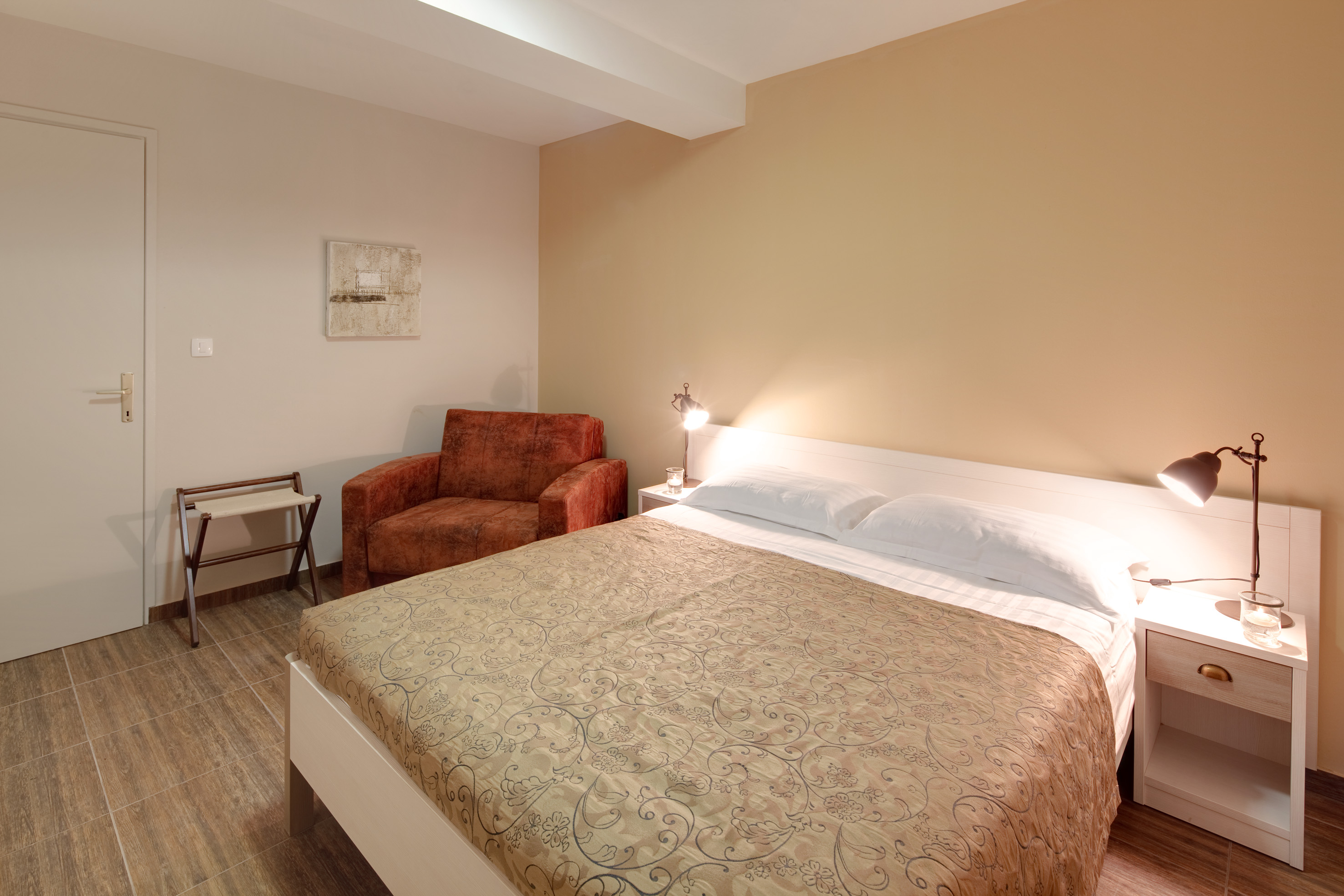 a bed with a lamp and a chair in a room