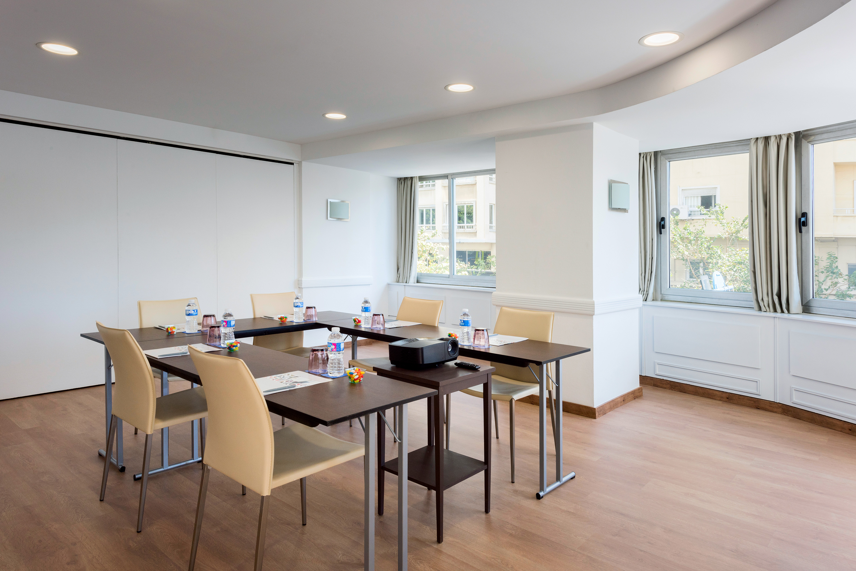 Modern U-shaped meeting room with projector, beige chairs, and large windows. - Tabarca - Hotel Alicante Gran Sol Affiliated by Meliá, 阿利坎特