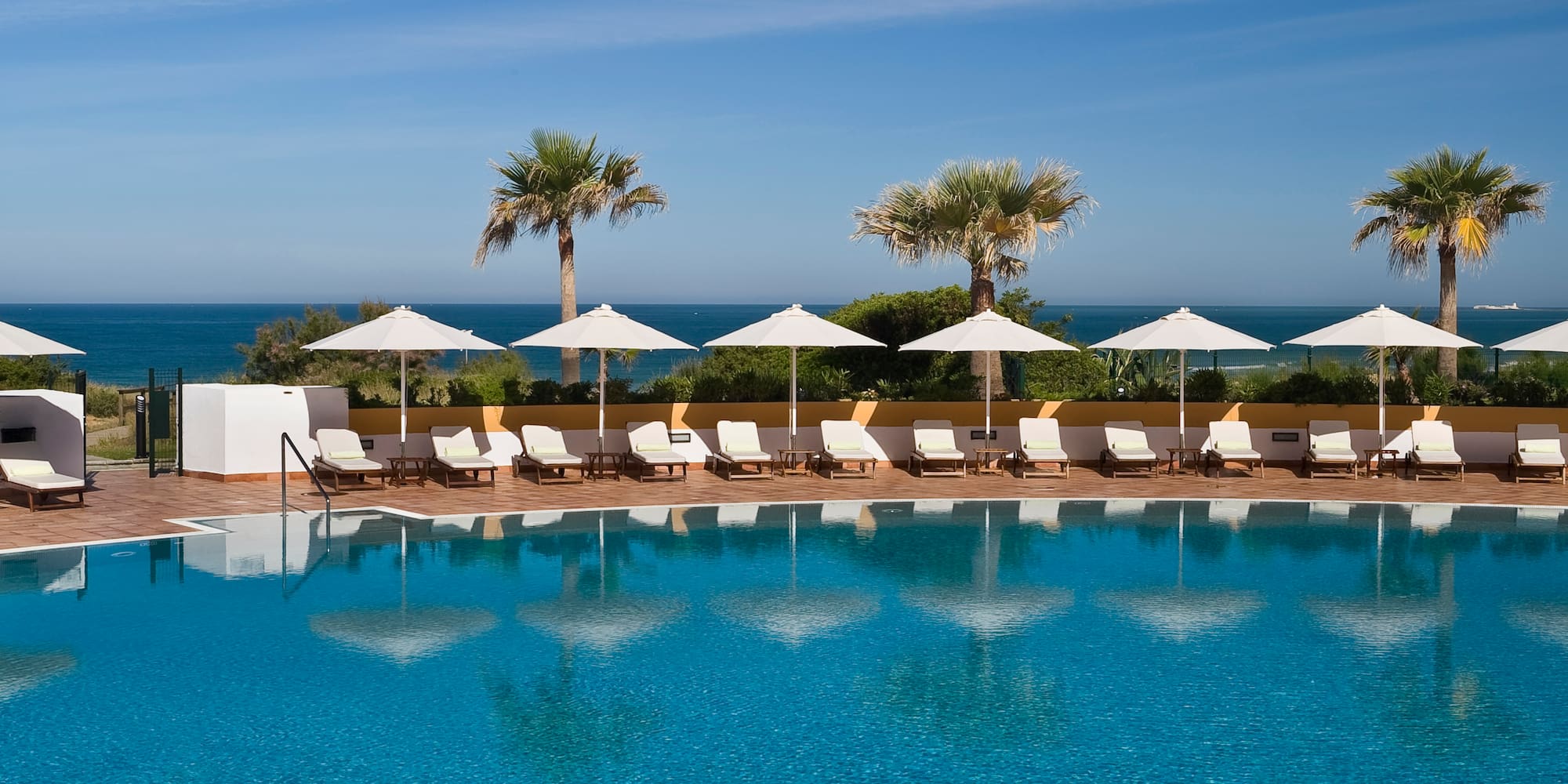a pool with umbrellas and lounge chairs