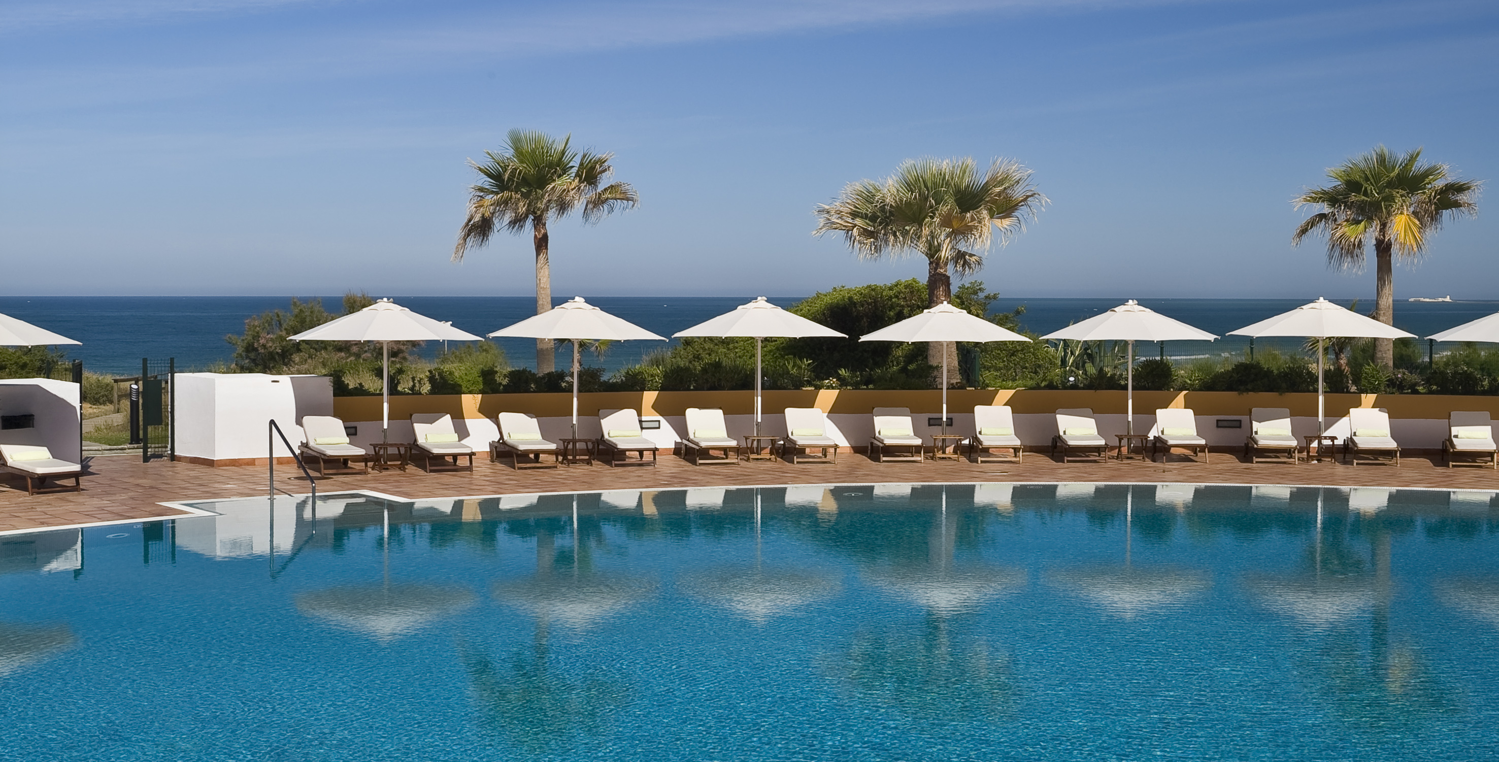 a pool with umbrellas and lounge chairs