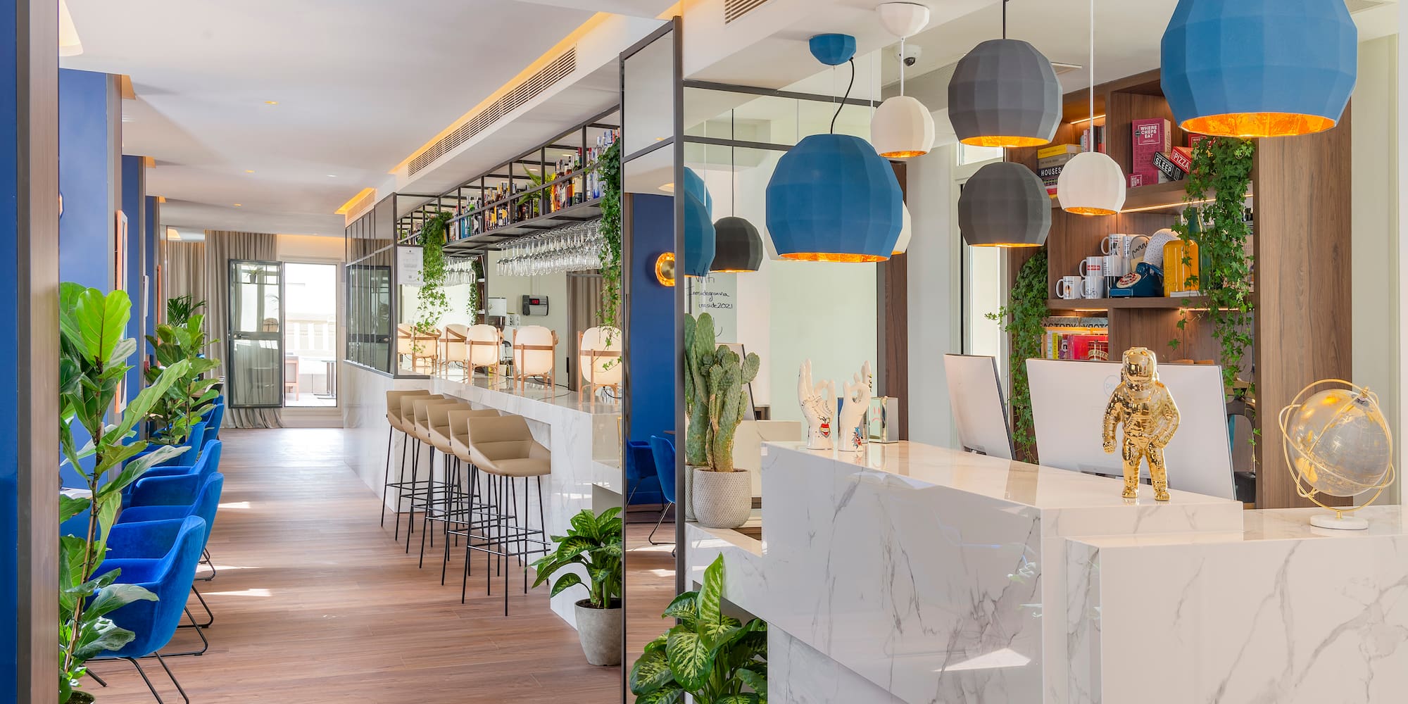 a lobby with a white counter and blue and white pendant lights
