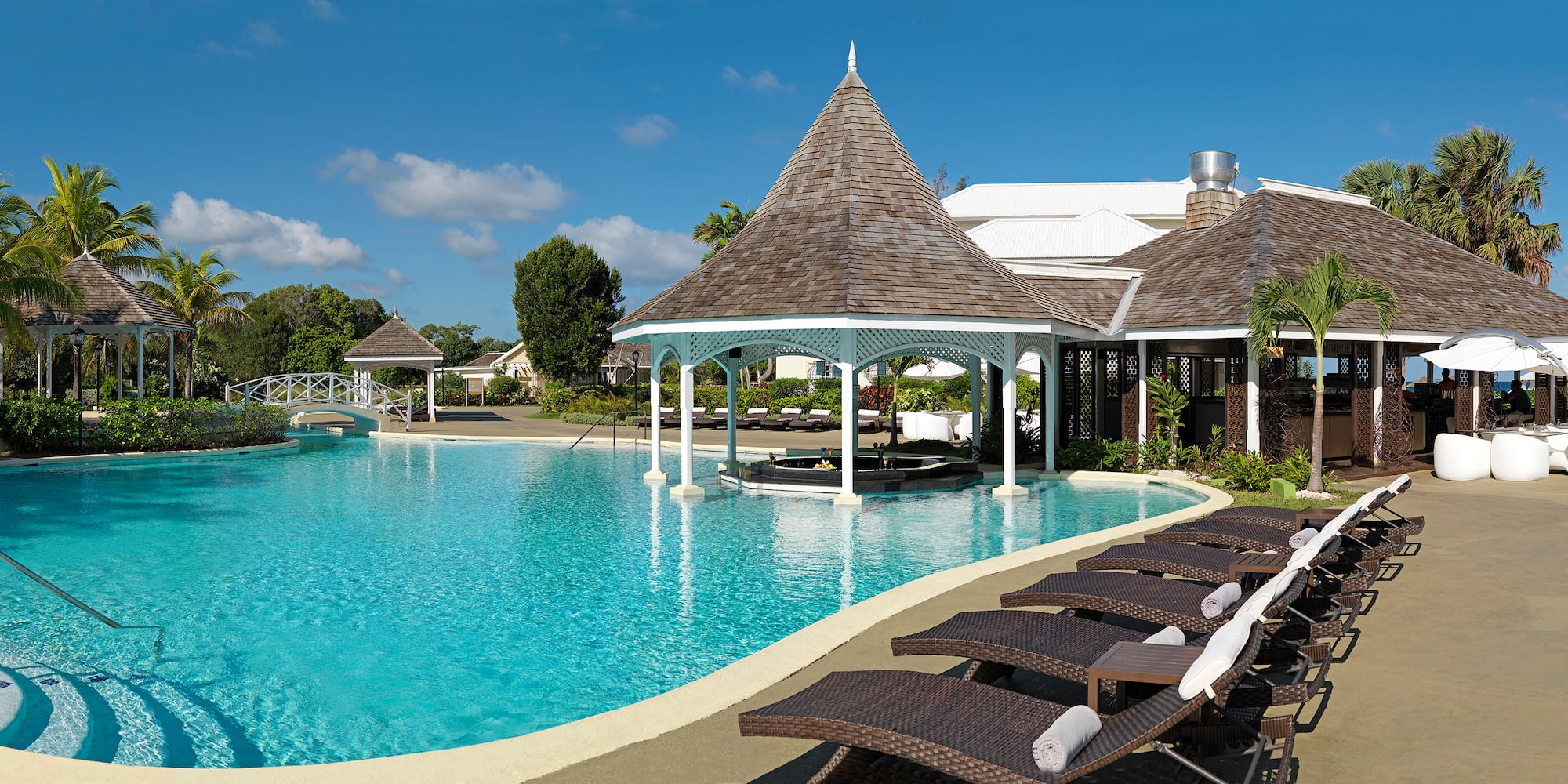 a pool with lounge chairs and a gazebo