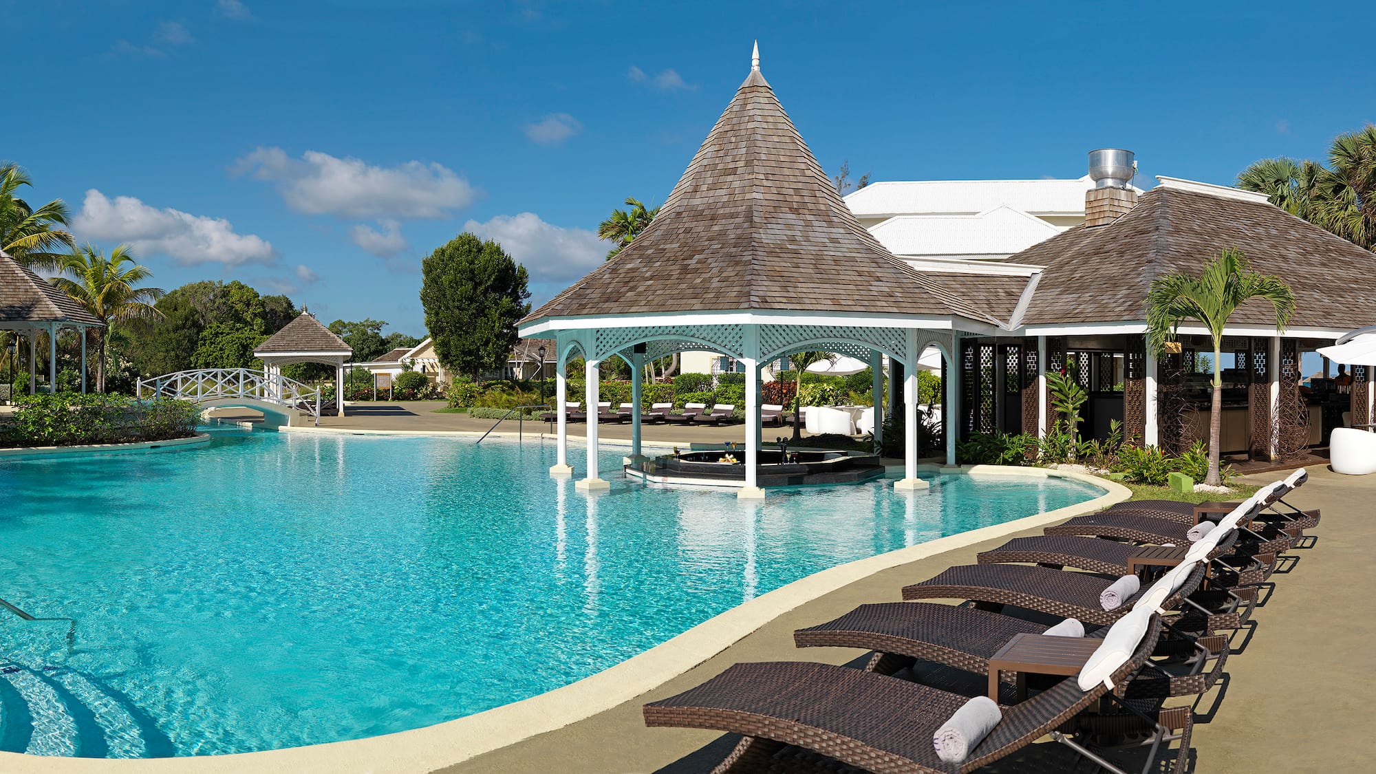 a pool with lounge chairs and a gazebo