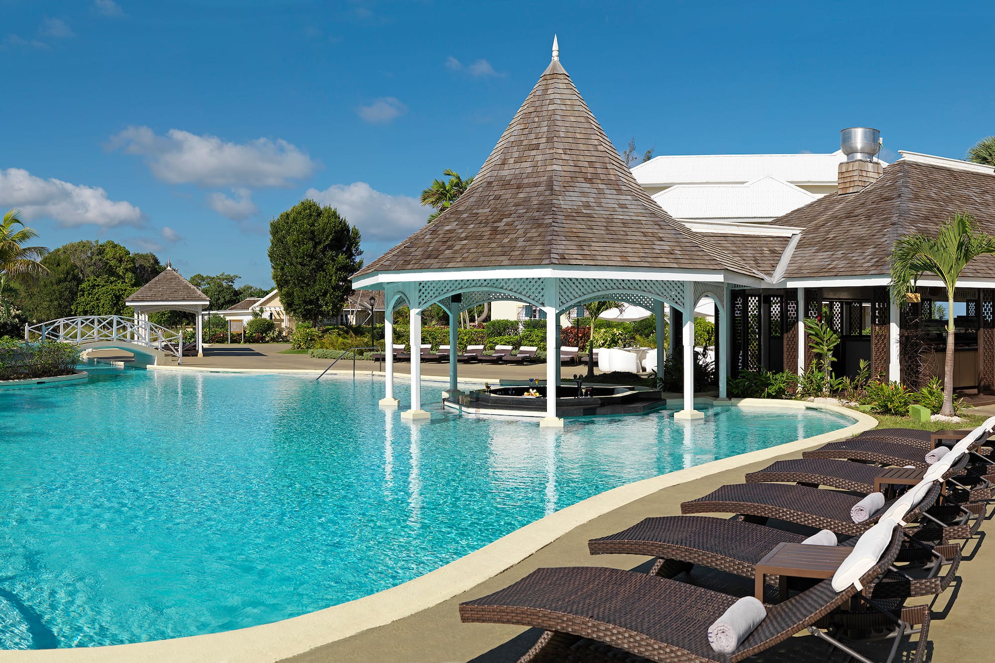 a pool with lounge chairs and a gazebo