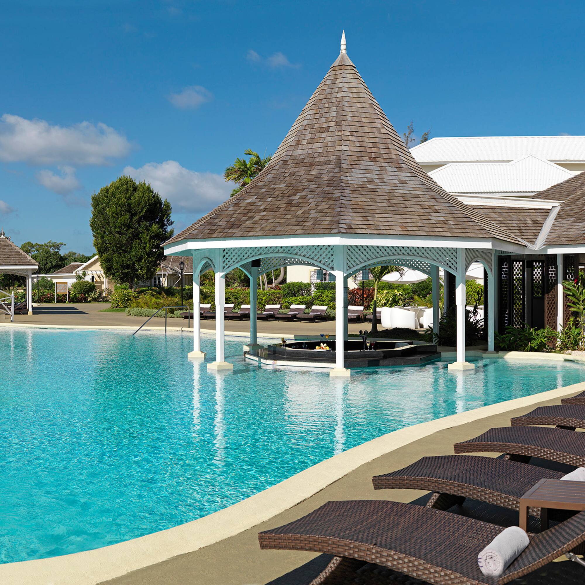 a pool with lounge chairs and a gazebo