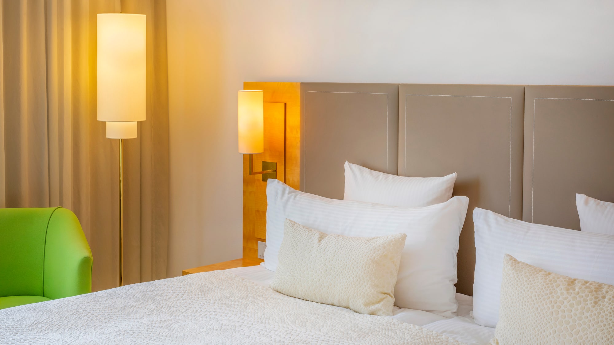 a bed with white pillows and a lamp next to it