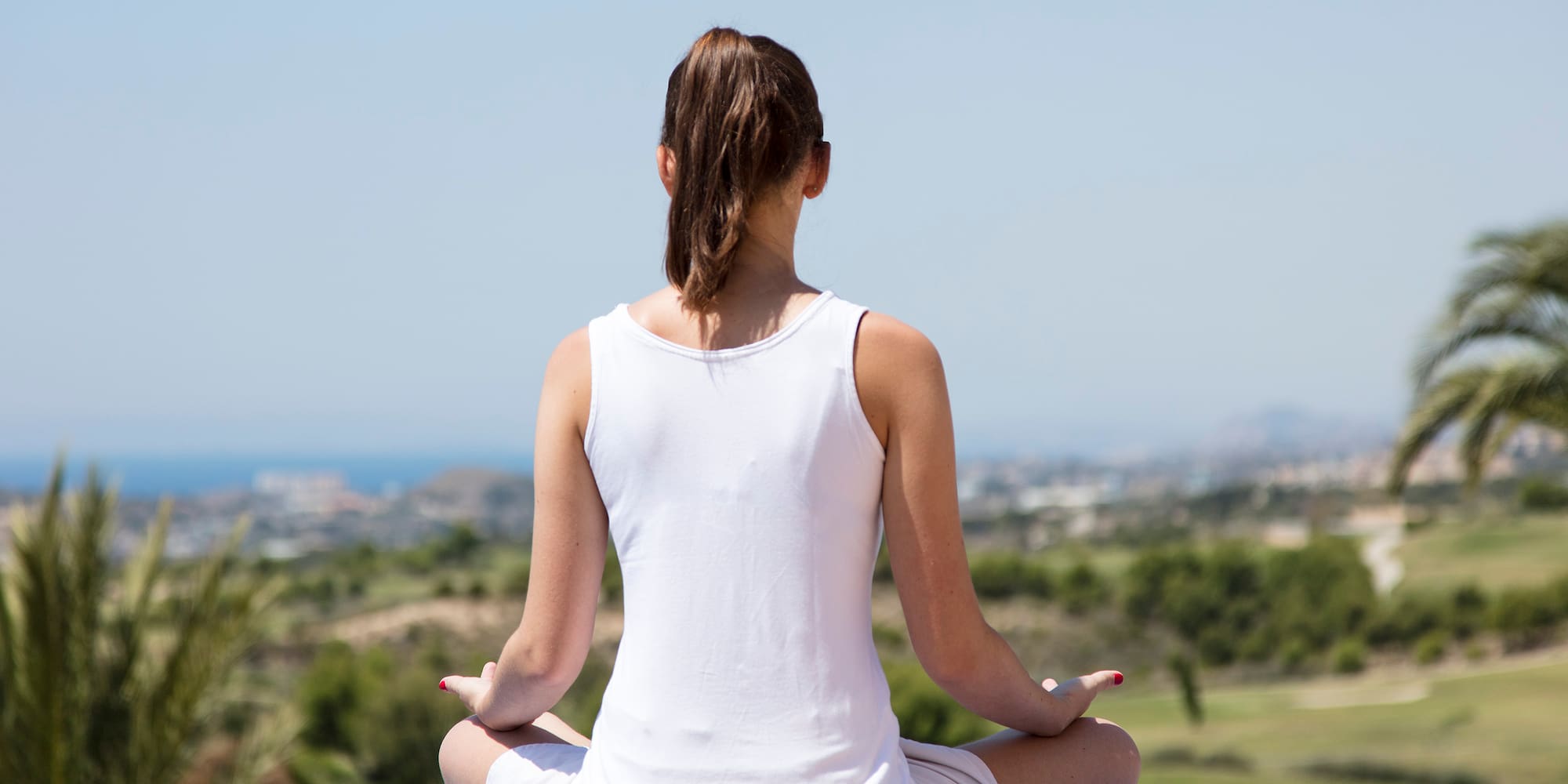 a woman sitting on a blue surface with her legs crossed