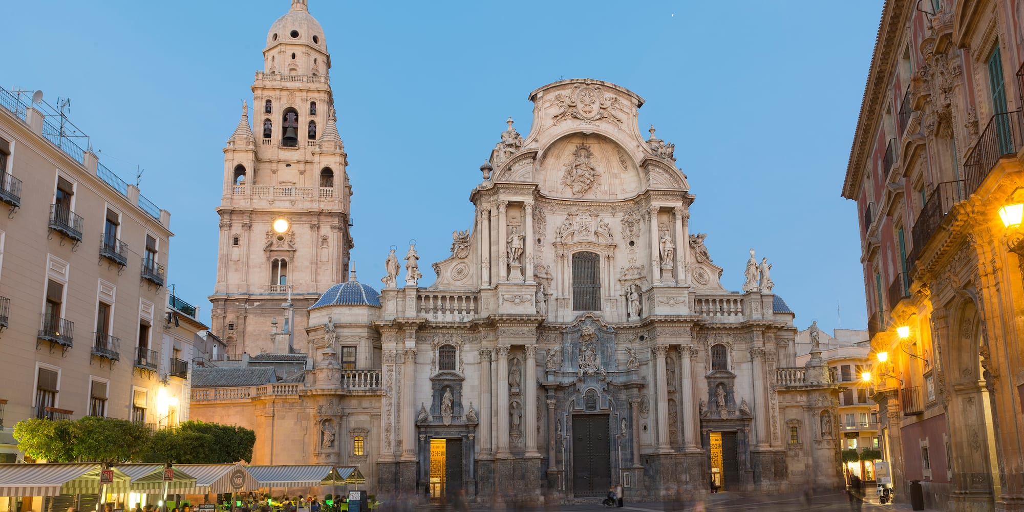 a large building with a clock tower with Cathedral of Murcia in the background