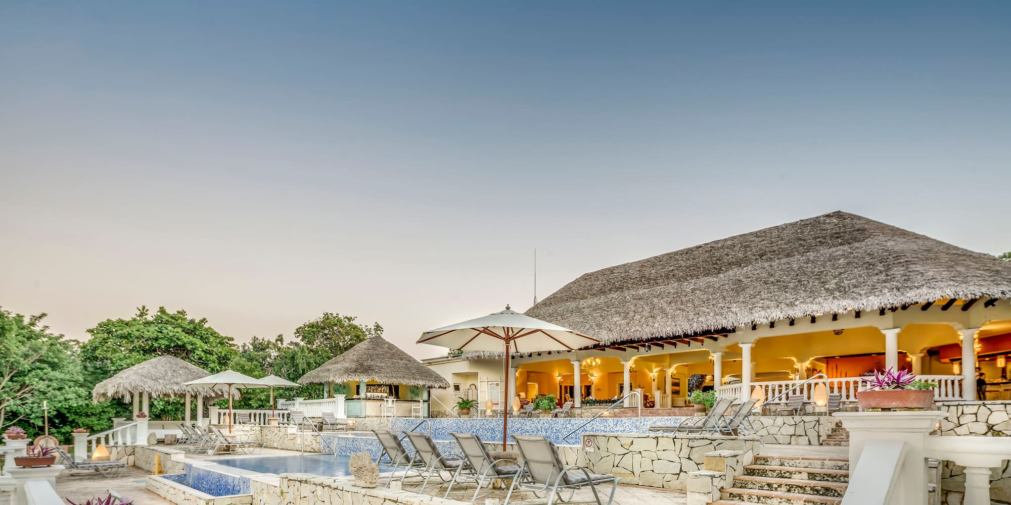 a pool and a building with umbrellas