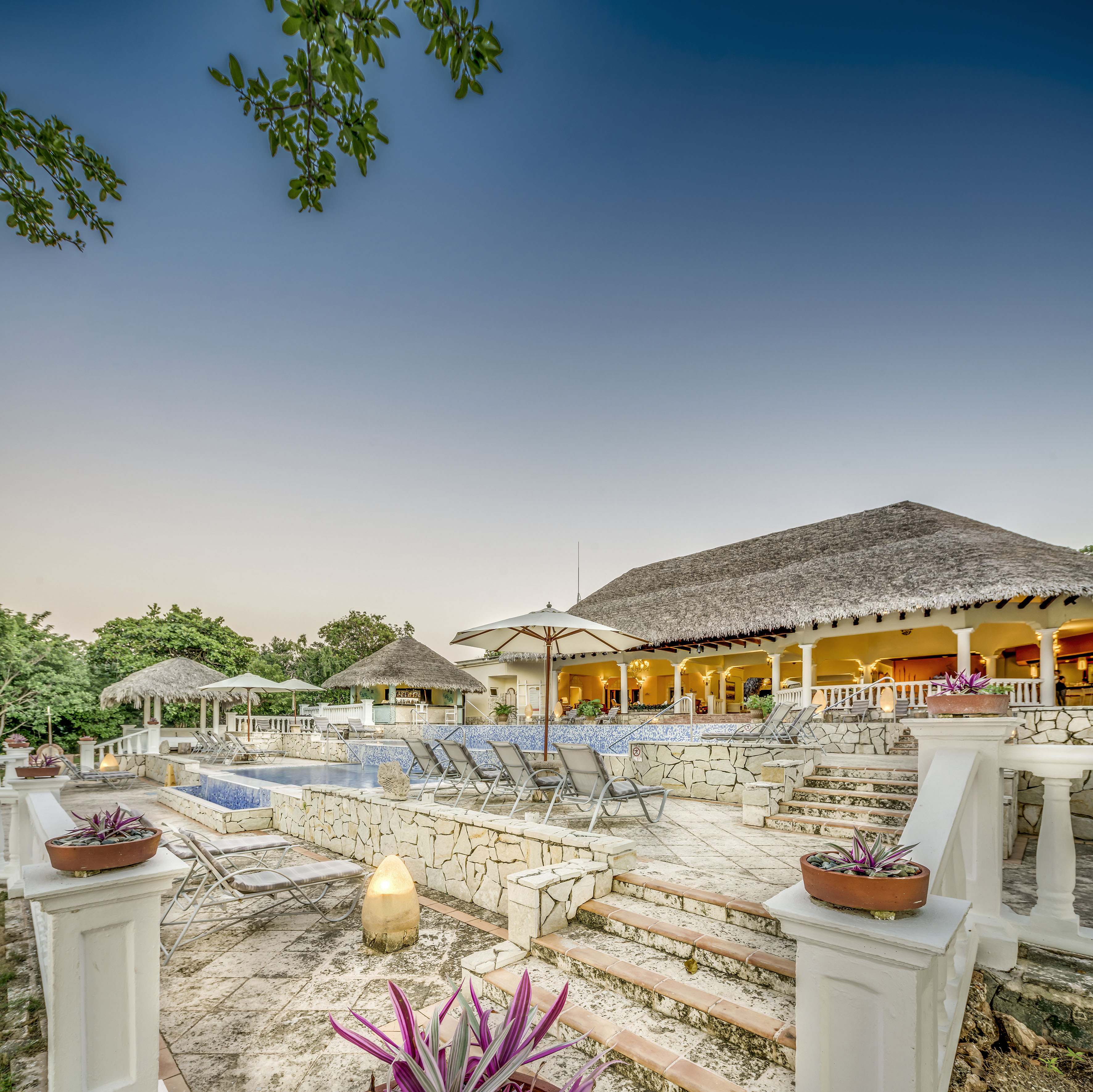 a pool and a building with umbrellas