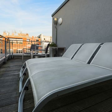 a deck with chairs and a table on a balcony