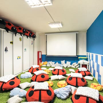 a room with ladybugs pillows and a projector screen