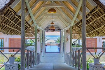 a walkway with a roof and a beach view