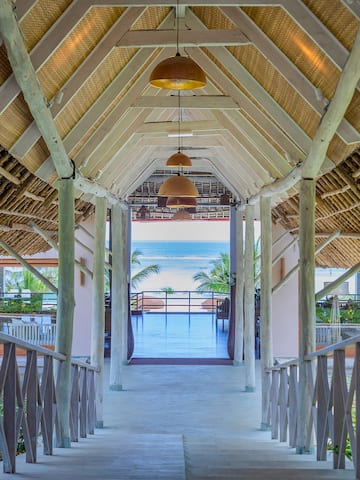 a walkway with a roof and a beach view