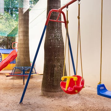 a playground with swings and a tree