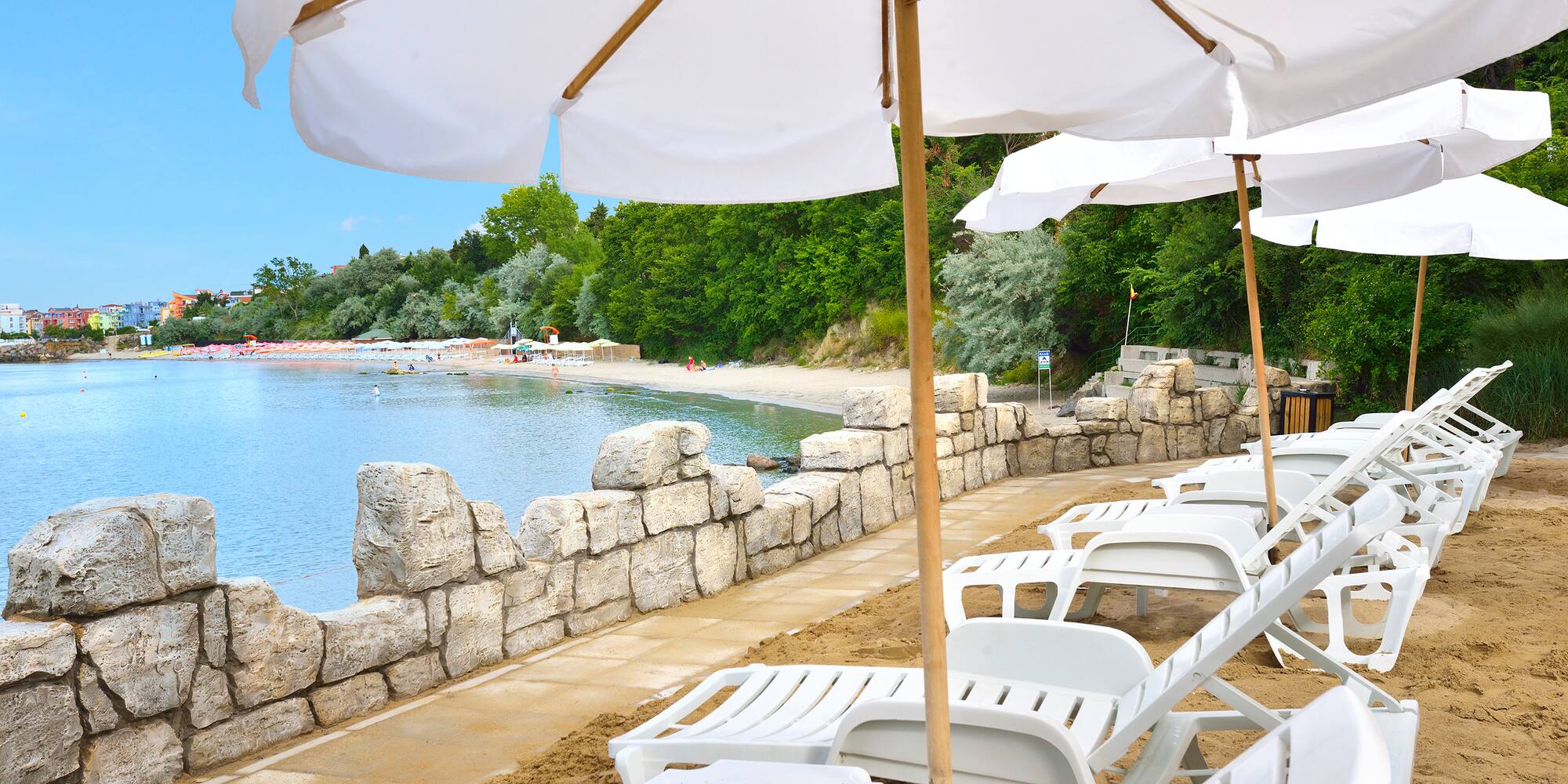 a beach with white umbrellas and chairs
