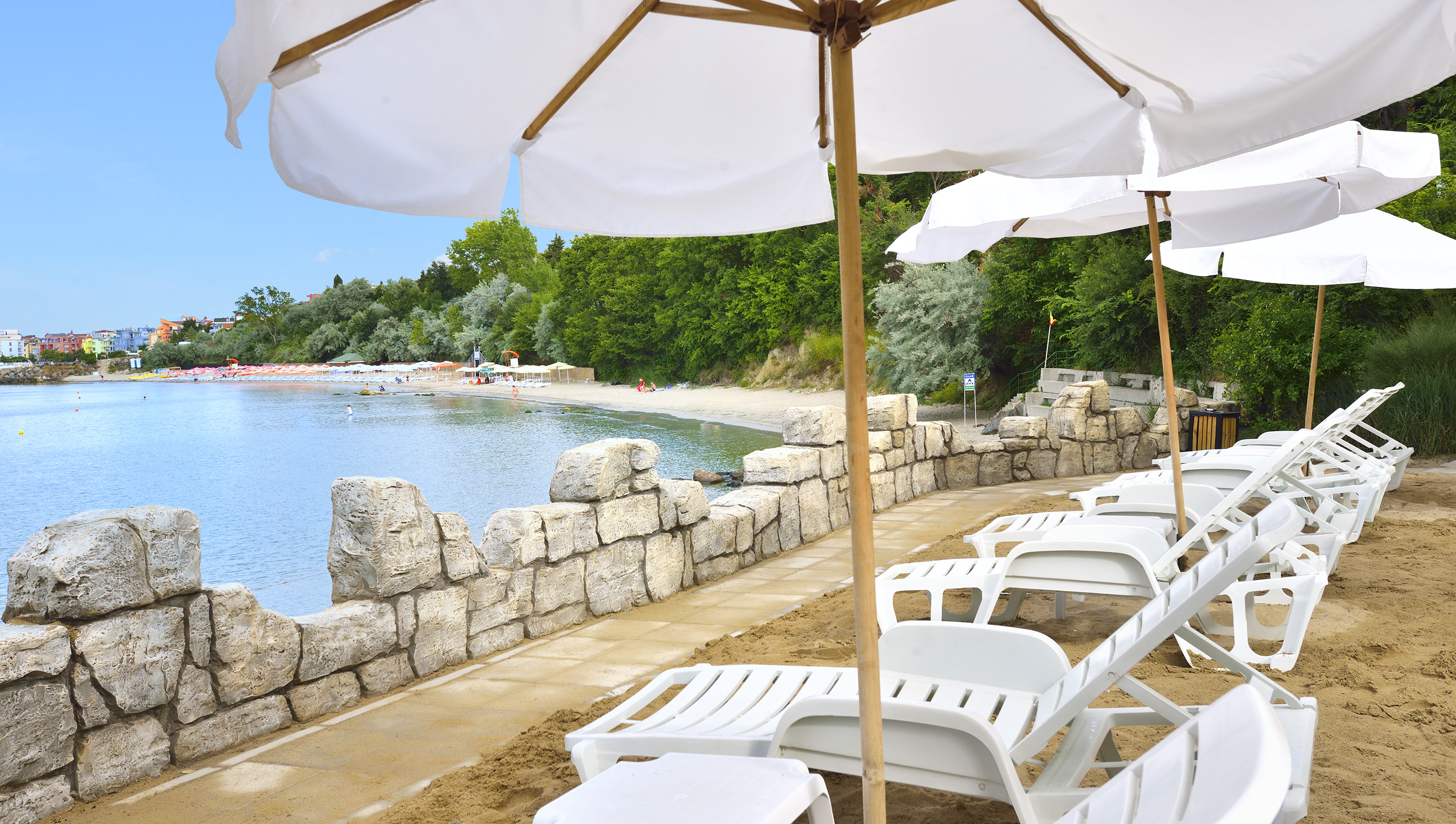a beach with white umbrellas and chairs