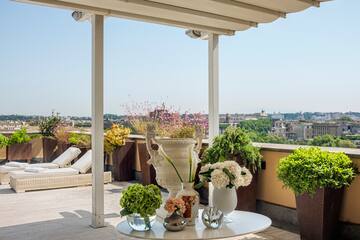 a patio with a table and potted plants