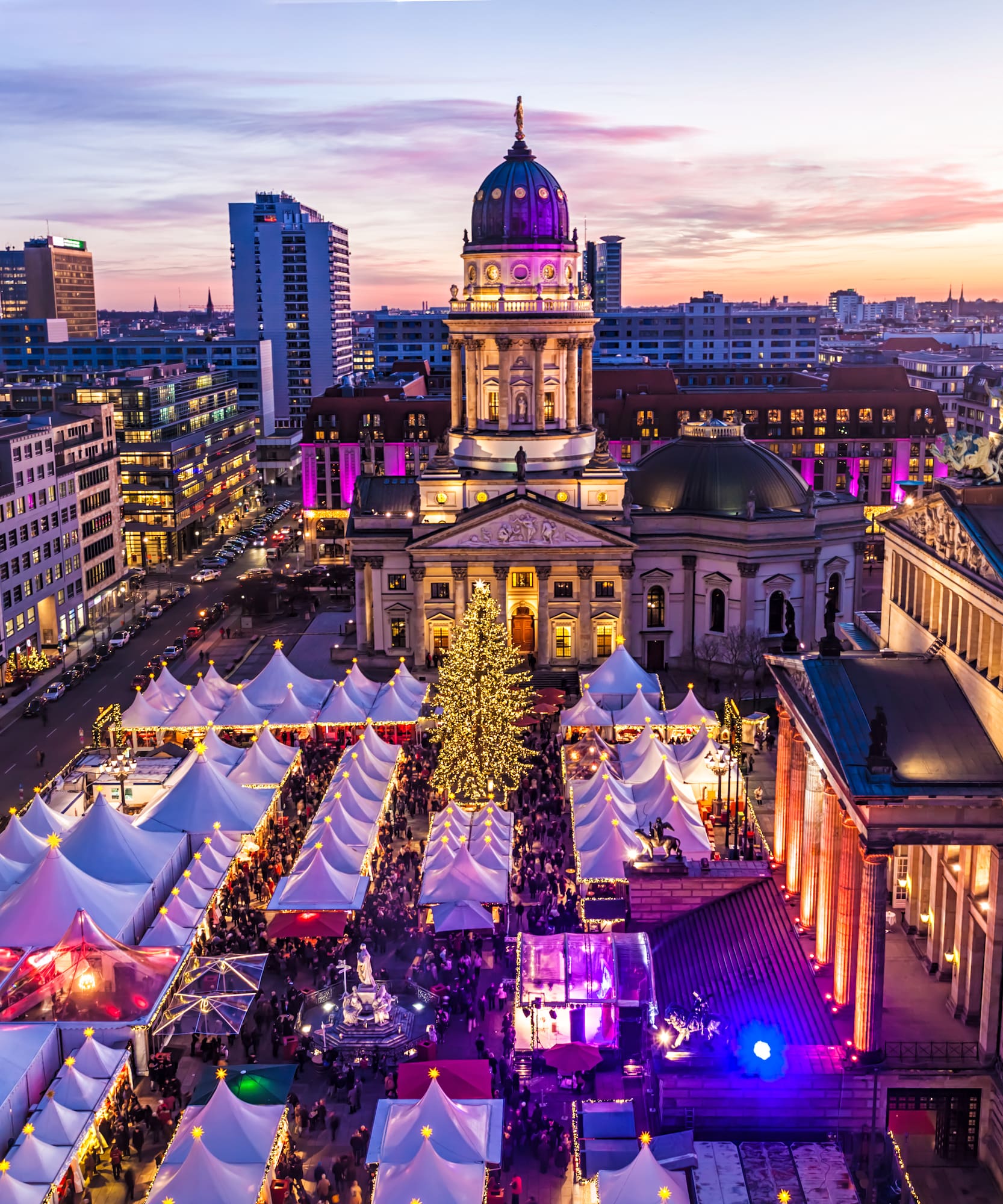 a city with tents and a large building with a large tree
