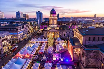 a city with tents and a large building with a large tree
