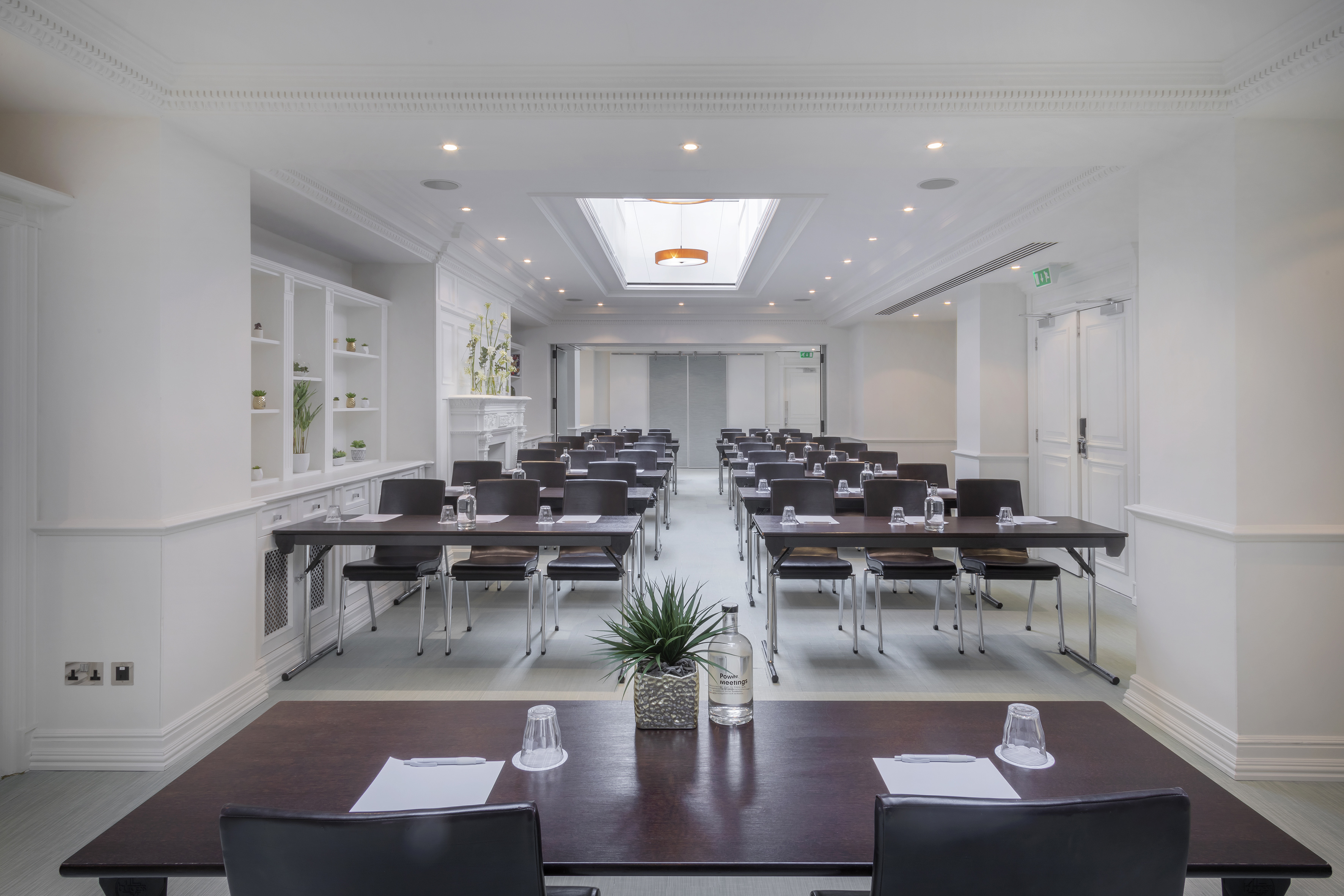 Modern conference room in classroom setup with skylight and white interior.