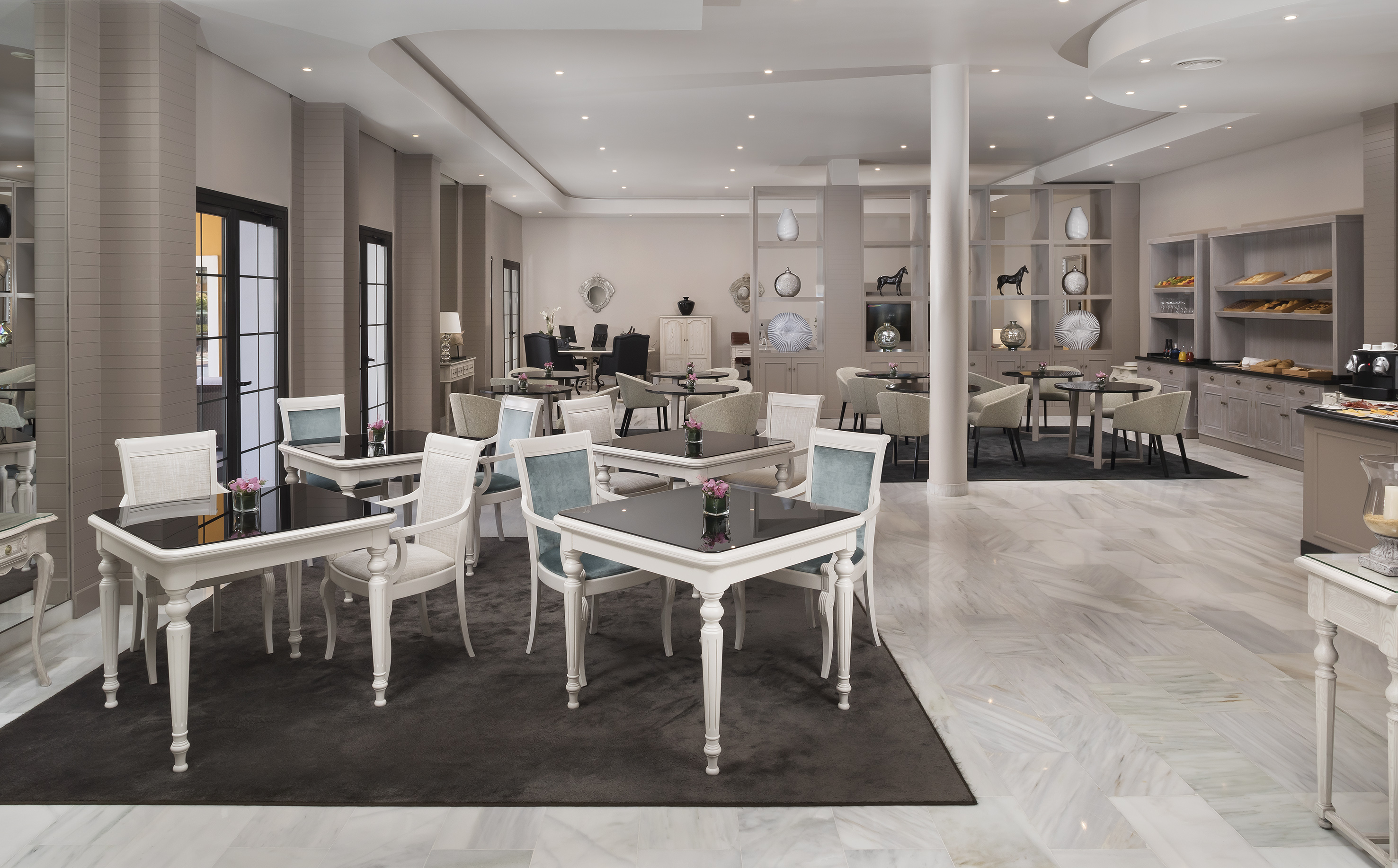 Luxurious hotel dining area with modern tables, marble floor, and breakfast buffet.