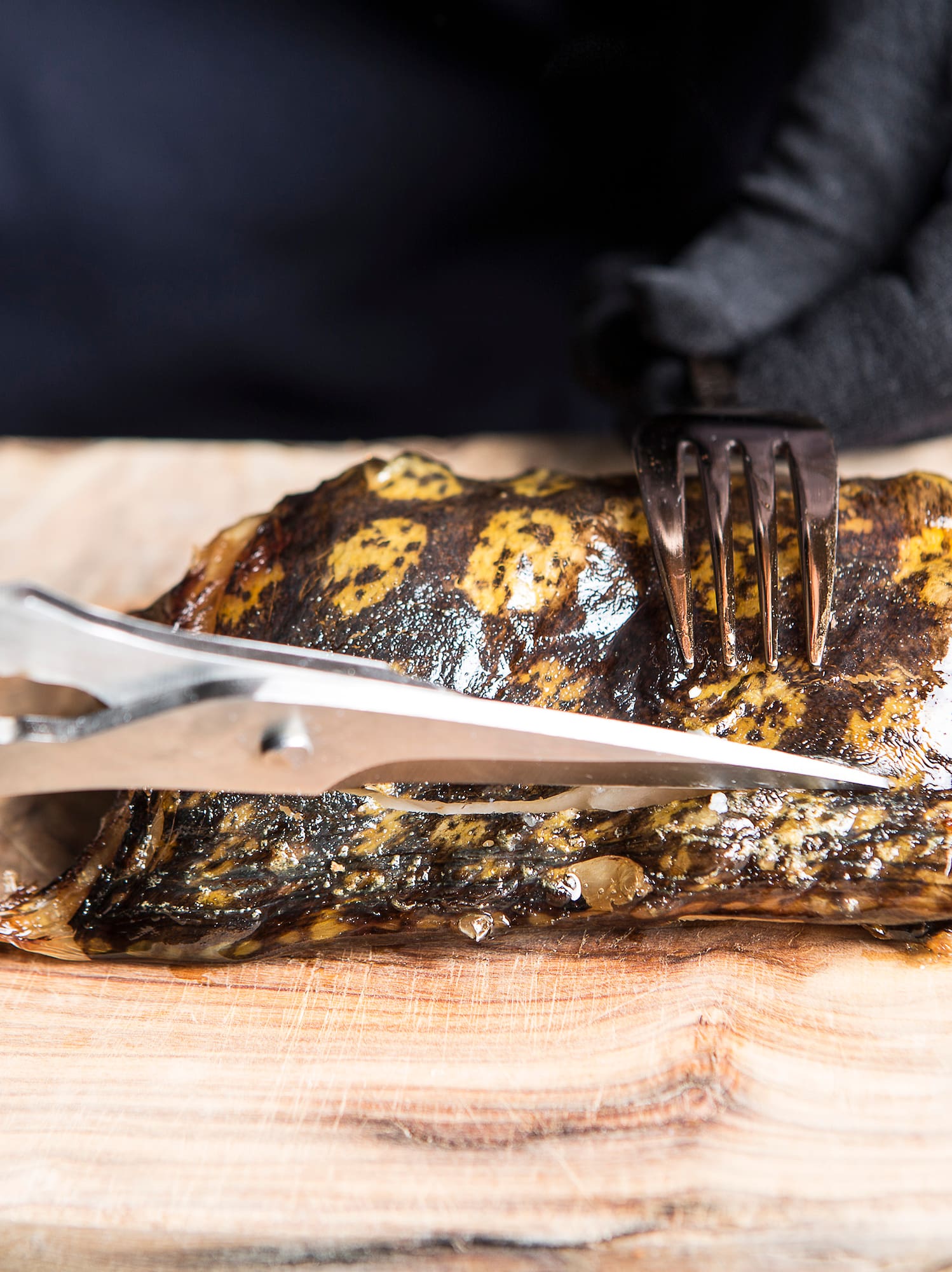 a person cutting a piece of meat with scissors