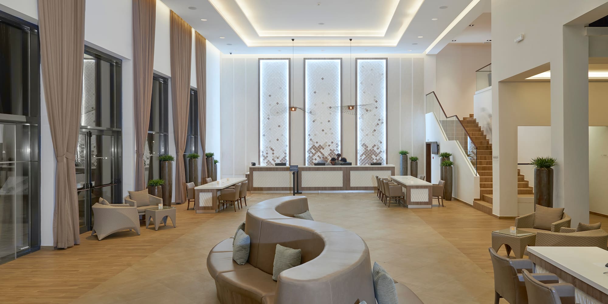 a room with a curved couch and a staircase