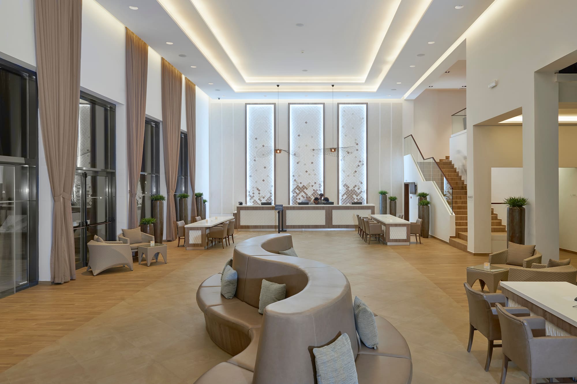 a room with a curved couch and a staircase