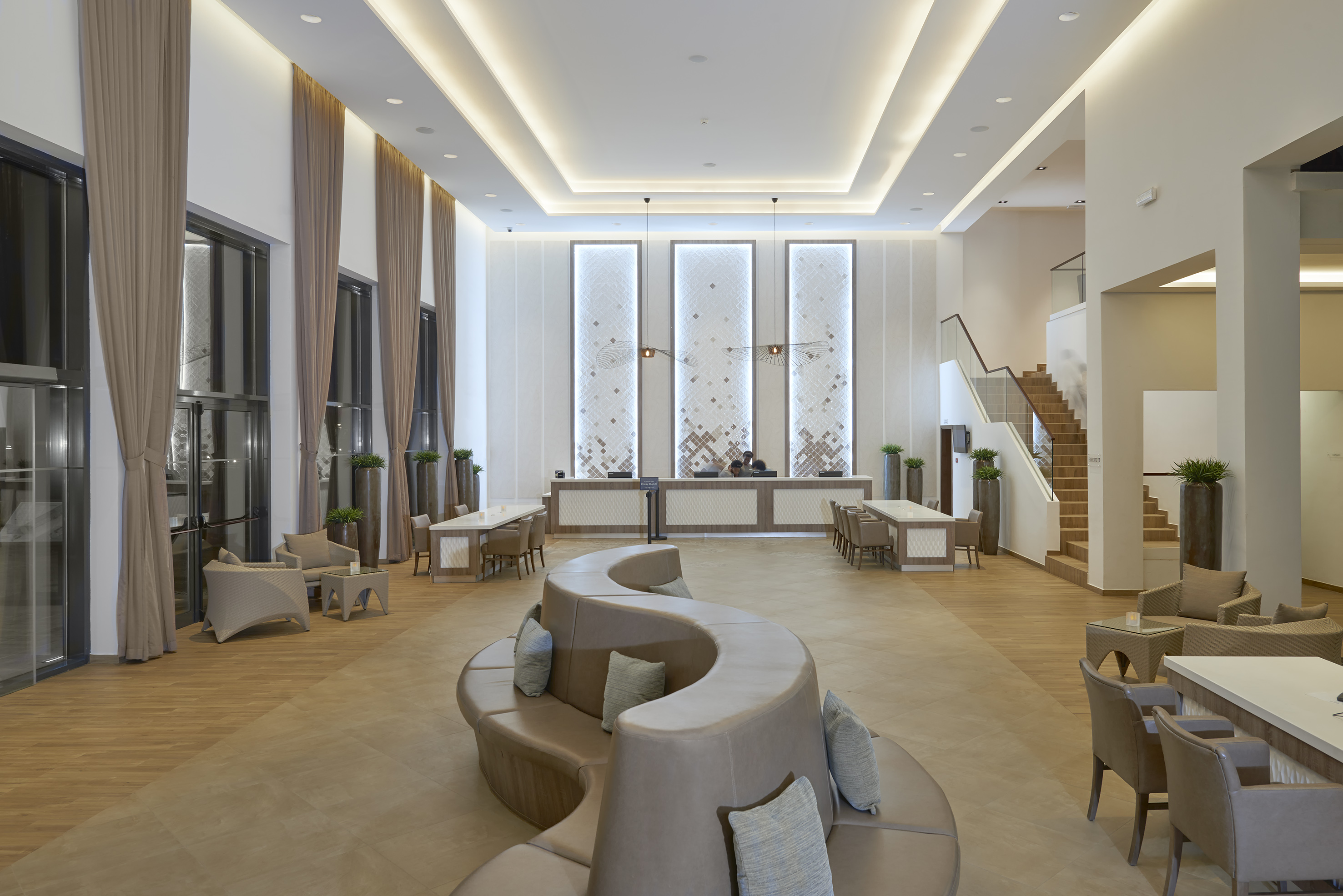 a room with a curved couch and a staircase