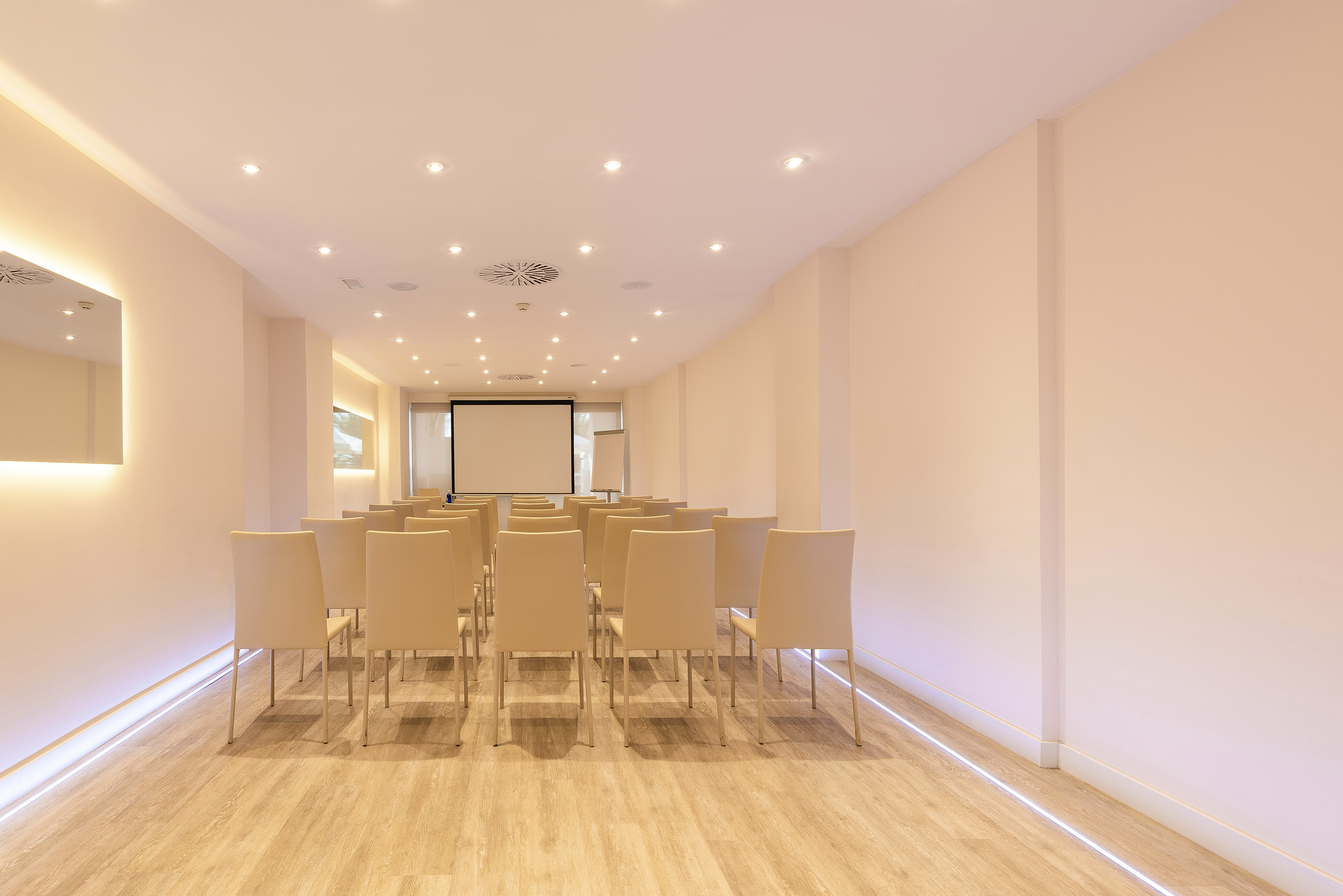 Modern empty conference room with beige chairs, projector screen, wood floor.