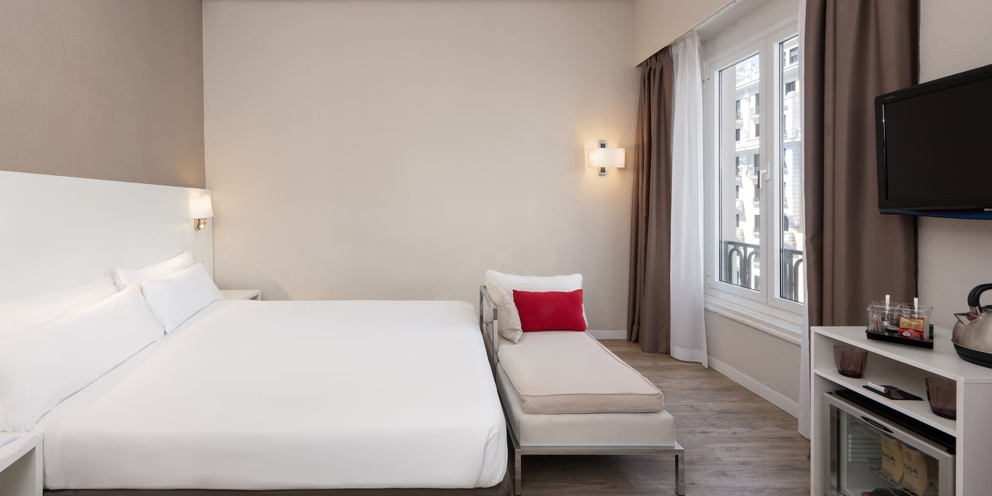 a bedroom with a bed and a chaise longue