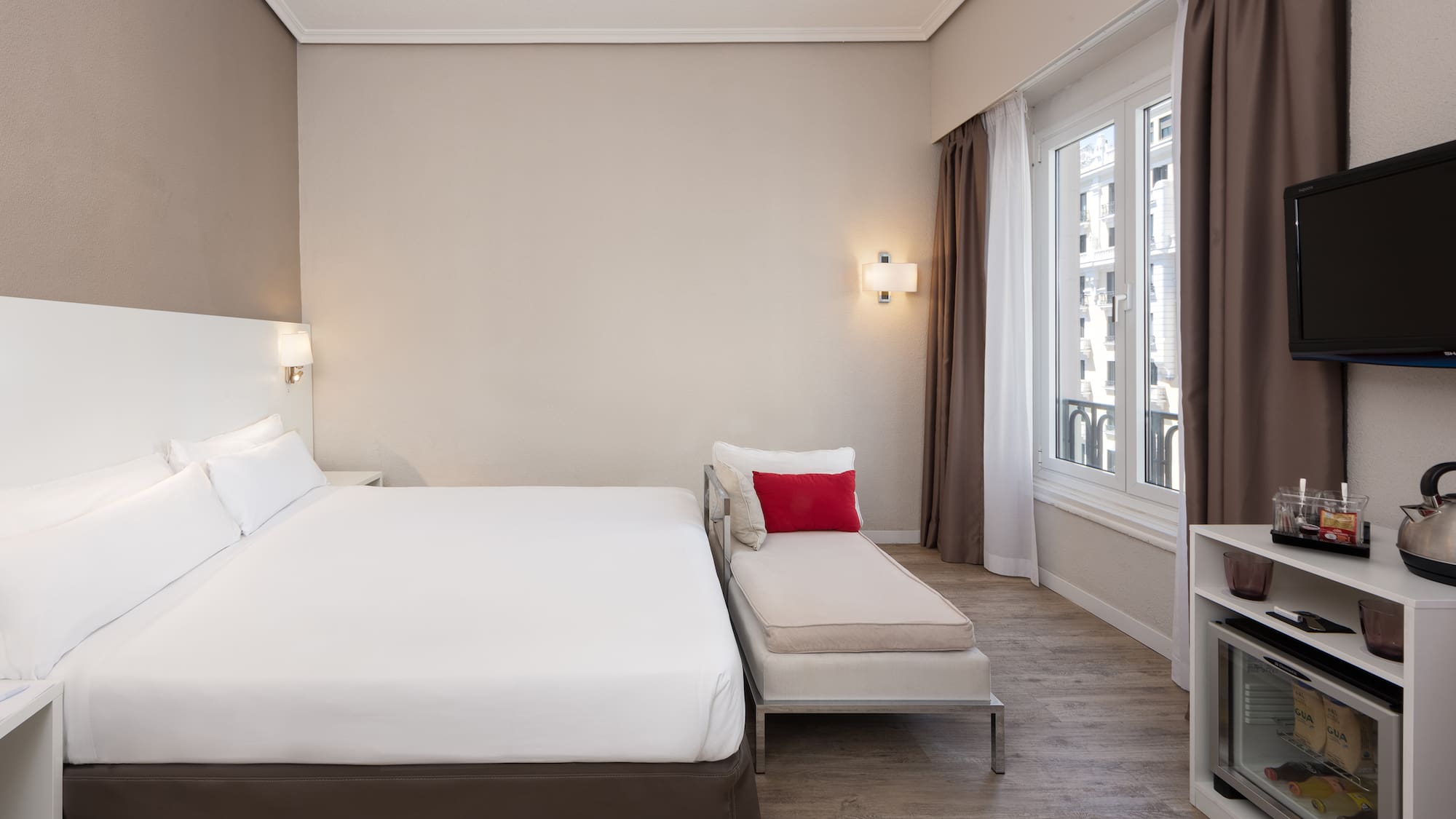 a bedroom with a bed and a chaise longue